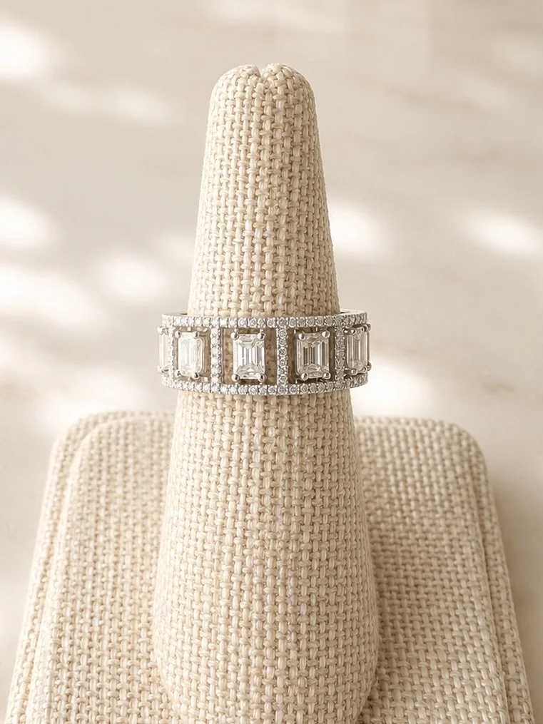 Emerald cut diamond ring on stand 9.1.26.jpeg