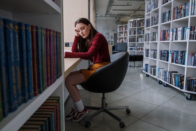 teenager in school library sad