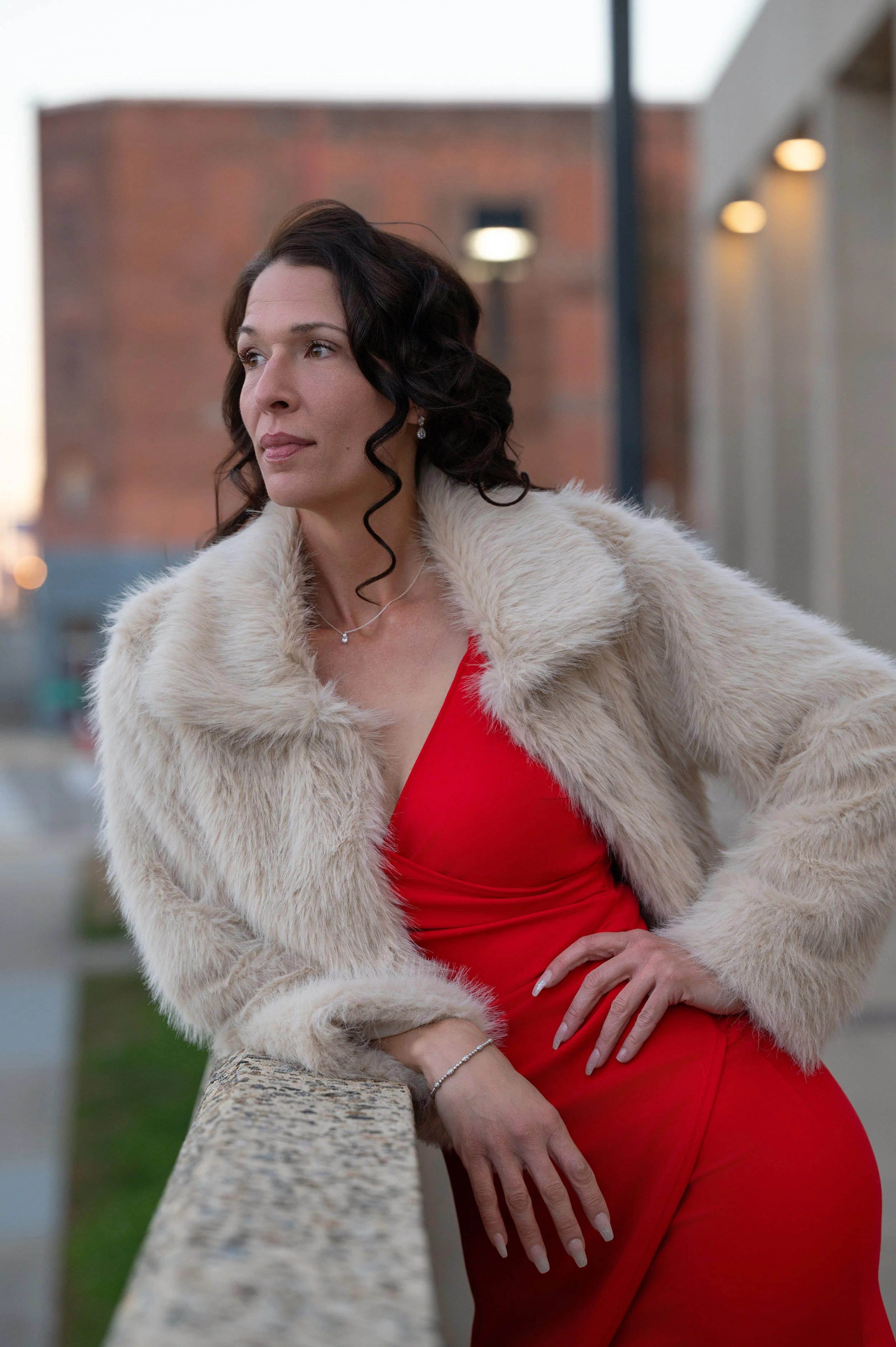 Editorial-style portrait of a woman in a red dress on a rooftop in Virginia.