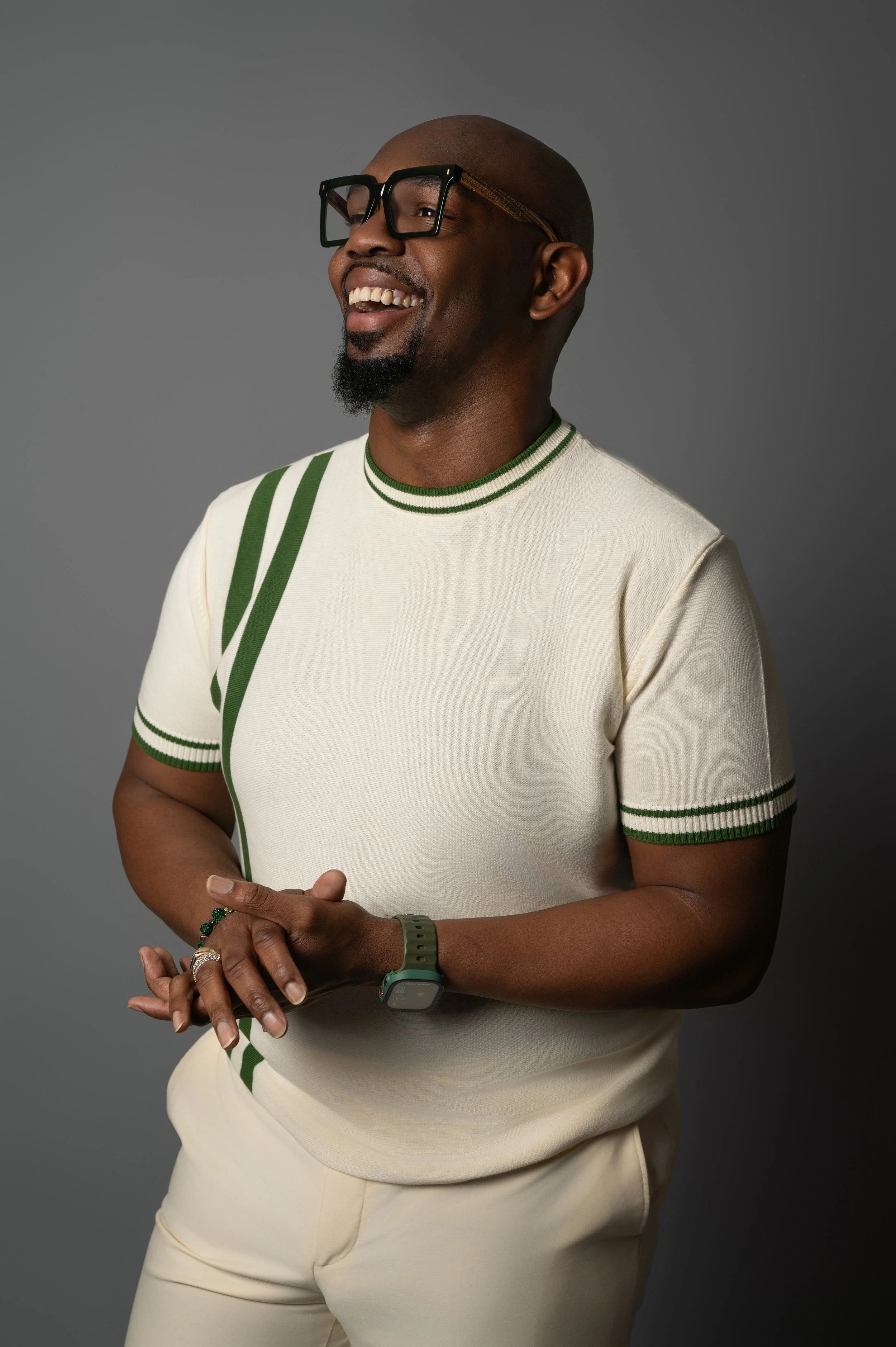 Professional studio headshot of a man smiling in front of a gray background.