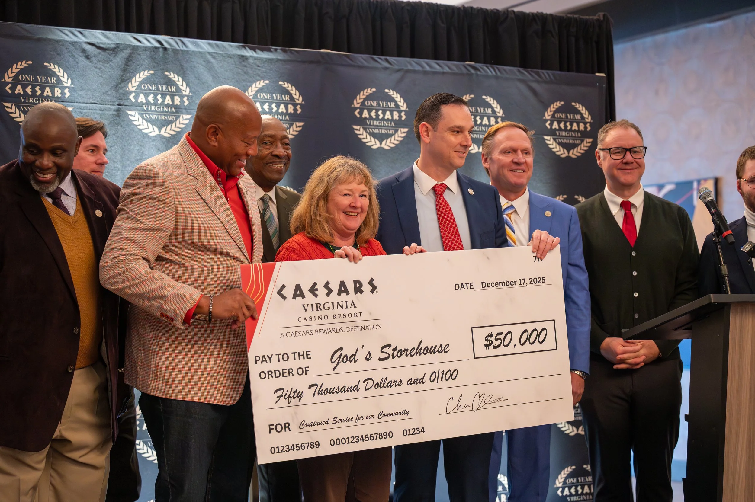 Group of people on stage holding a large check
