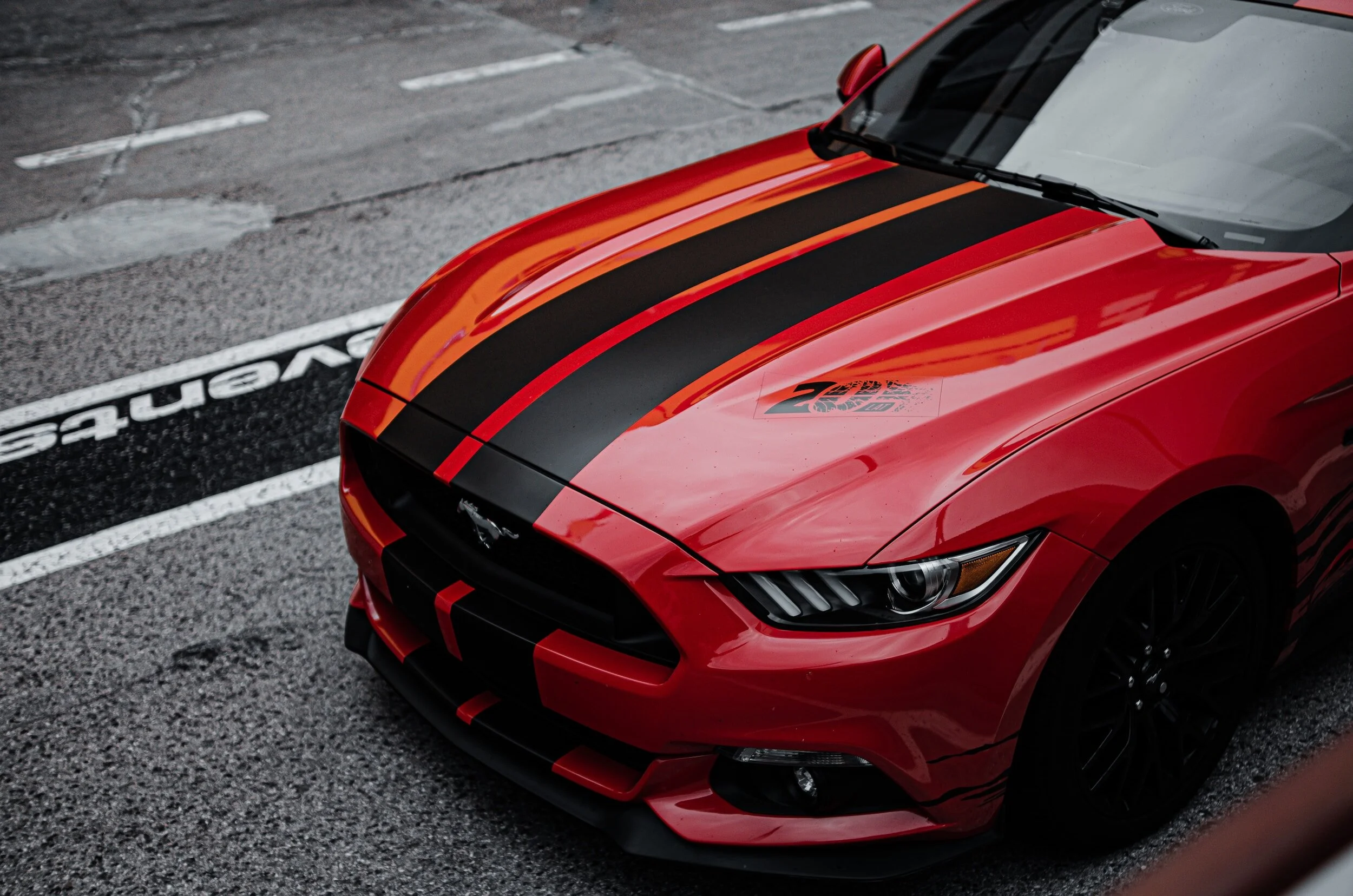 A red Mustang with black vinyl stripes
