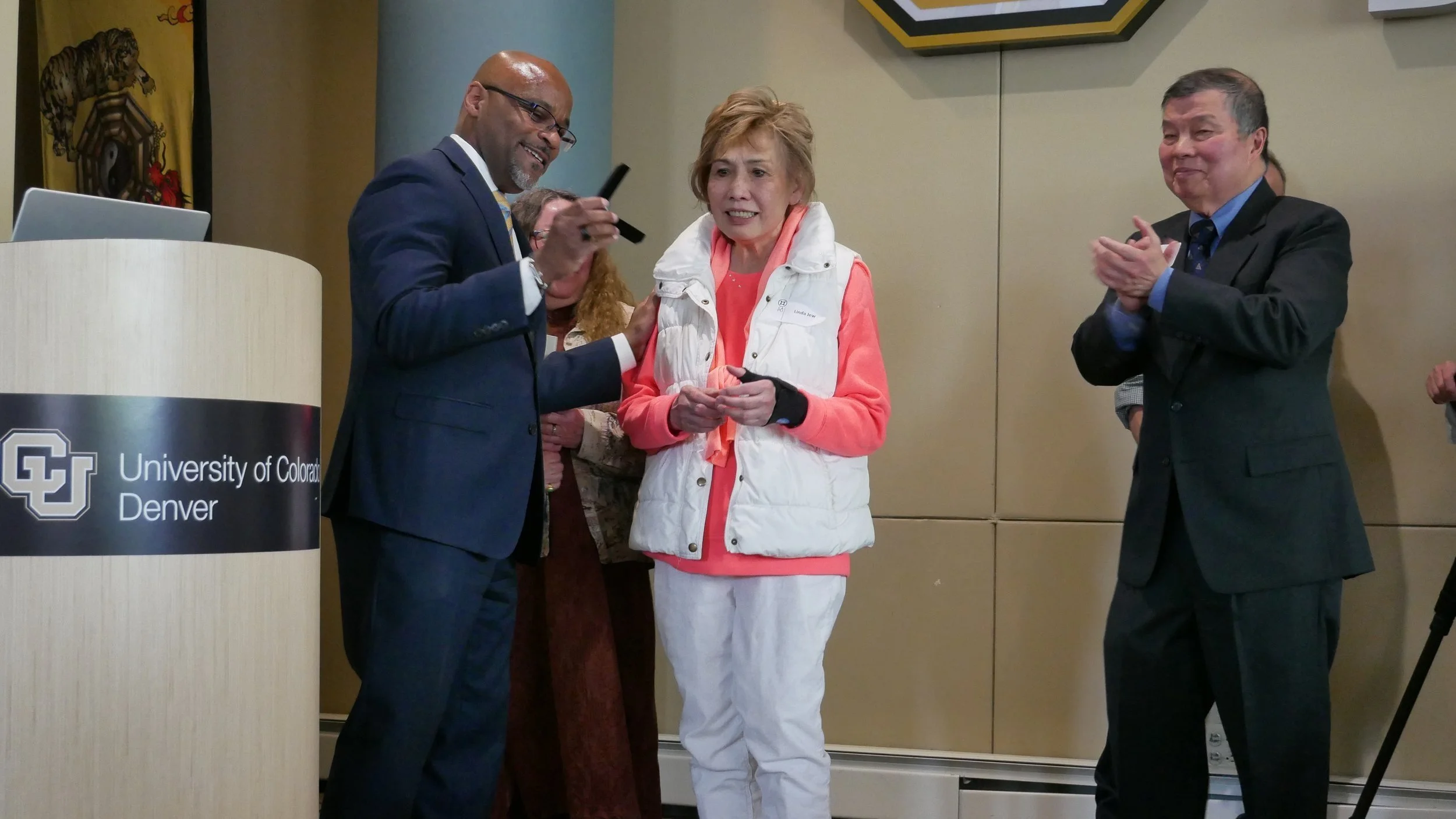 Denver Mayor Michael B. Hancock presenting Linda Jew a gift