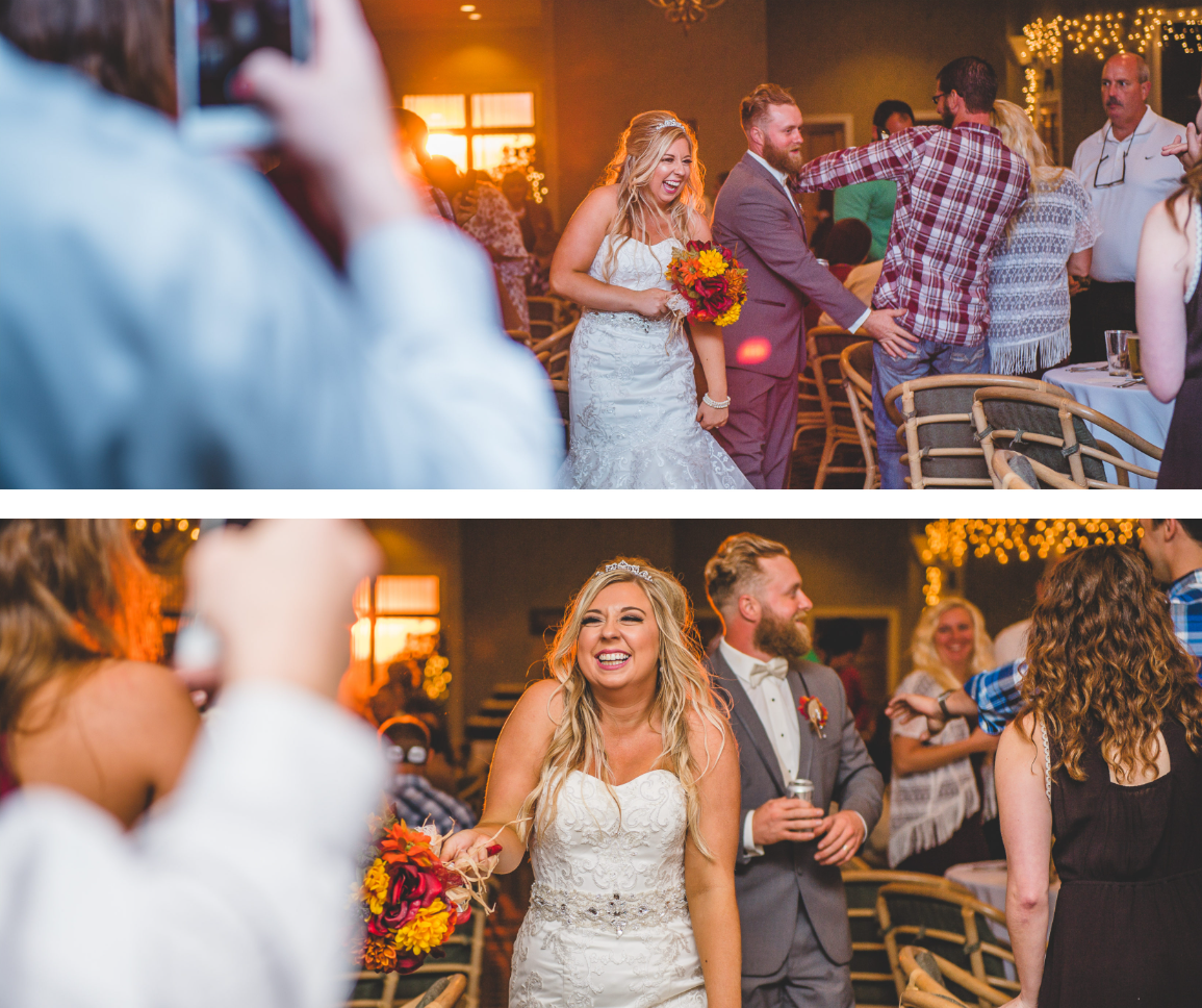 Two photos from a wedding reception show a bride in a white lace wedding dress holding a bouquet of red, yellow, and orange flowers, smiling and being photographed. In the first photo, she is walking into the room with her groom, who is wearing a gra