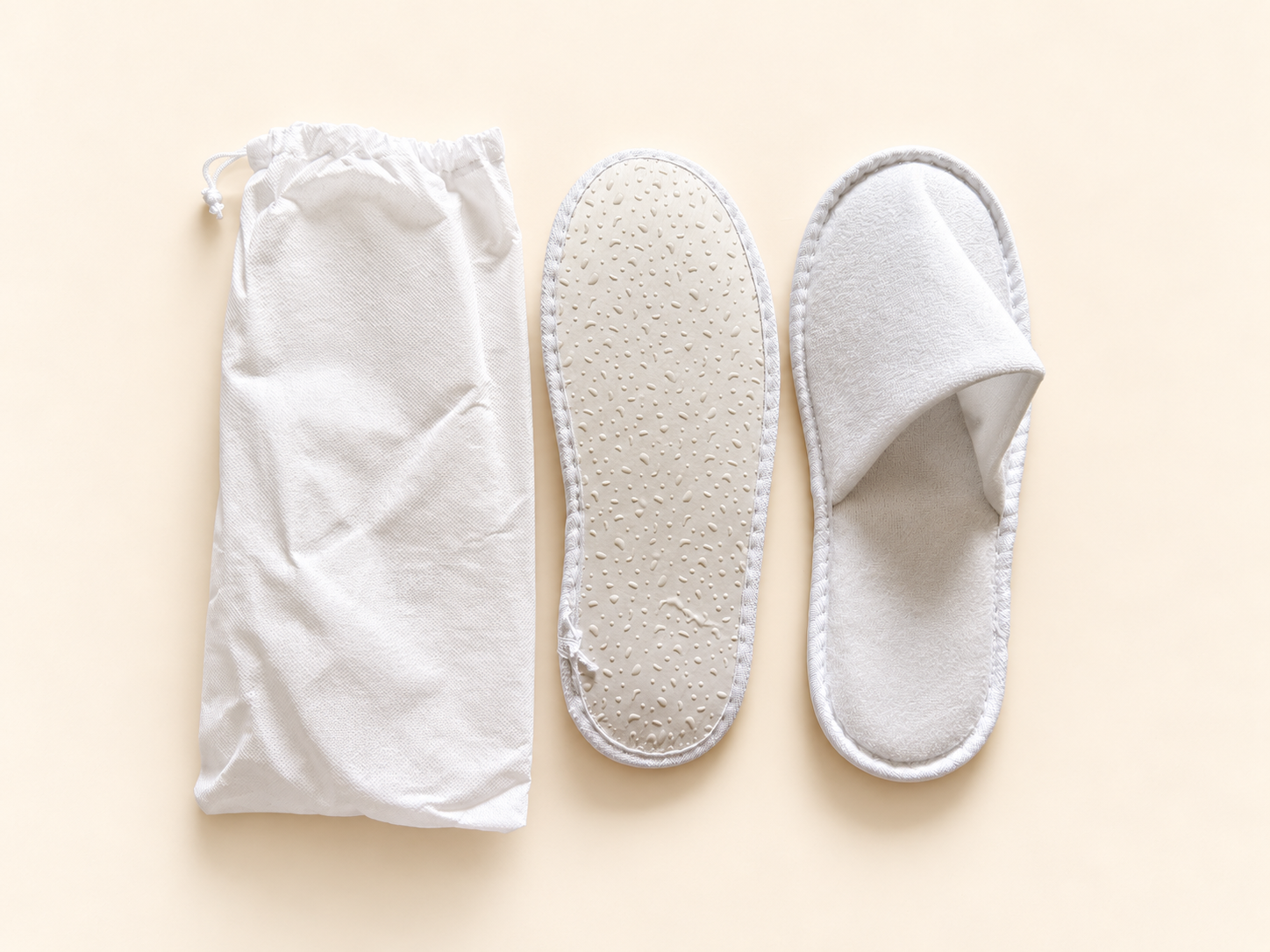 White textured spa slippers with a drawstring storage bag