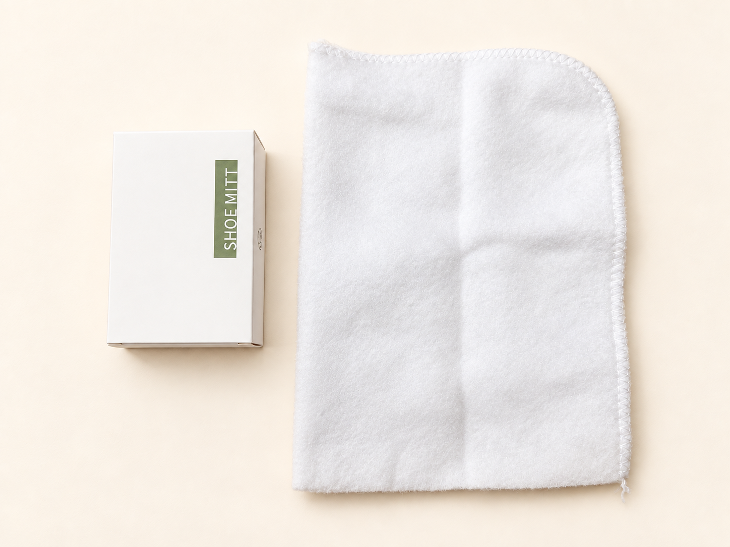 White shoe mitt beside its packaging on a light background