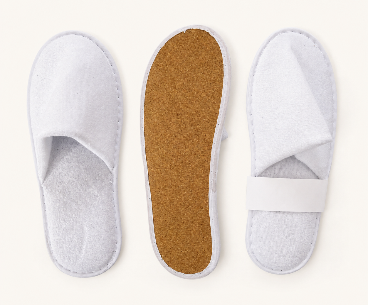 Three white disposable spa slippers shown from the top and underside, including one with a brown textured sole.