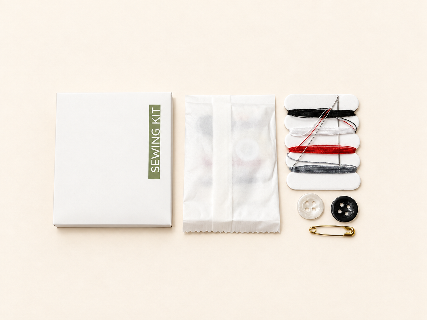 Flat lay of a sewing kit with thread spools, needles, buttons, a safety pin, and fabric packaging.