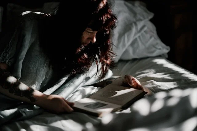 woman-reading-book-on-bed