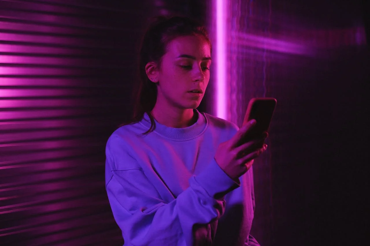 teen in-purple-sweater-using-mobile-phone