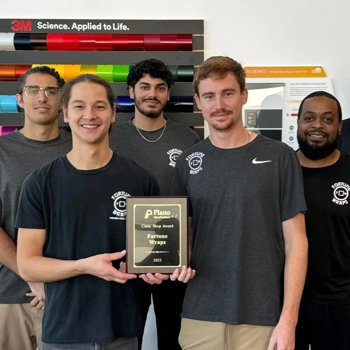 Everyone from the shop gathered around after recieving an award from the city of plano for having a recognized clean shop