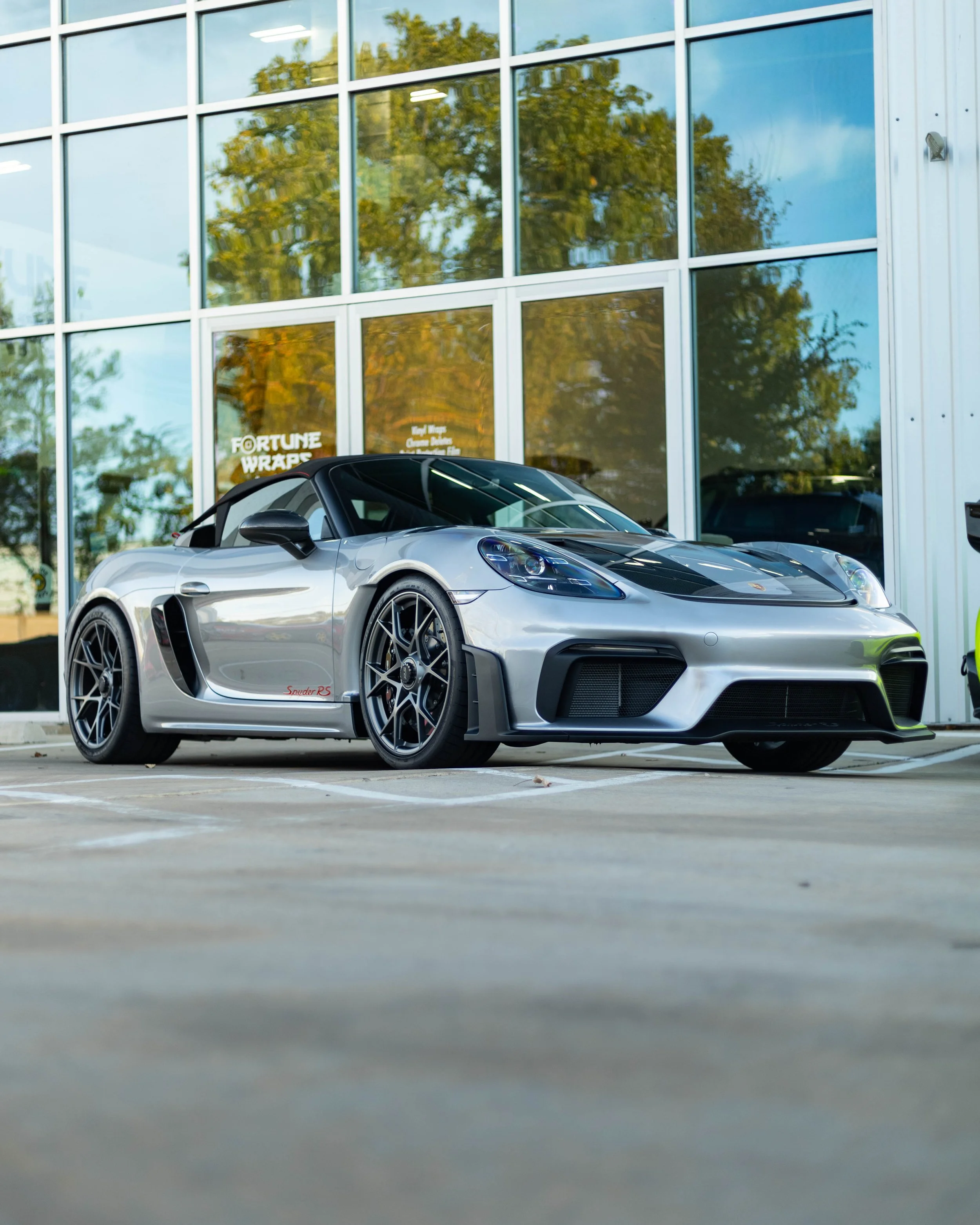 A silver Convertible Porsche 718 Spyder RS That we installed a PPF track package on and Ceramic Tinted