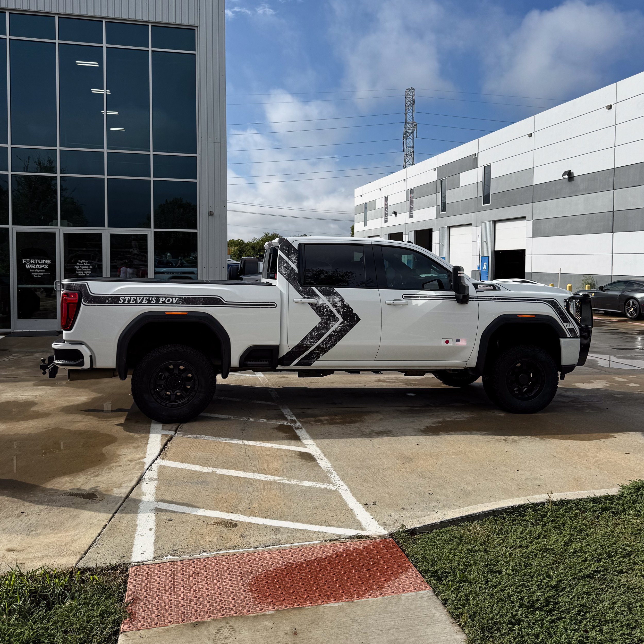 White GMC pickup truck owned by content creator, influencer, and Youtuber, Steve's POV, that we installed patter vinyl accents and custom graphics for to give the truck a feel of classic american muscle car design. Yenko Stripe, Camaro Stripe