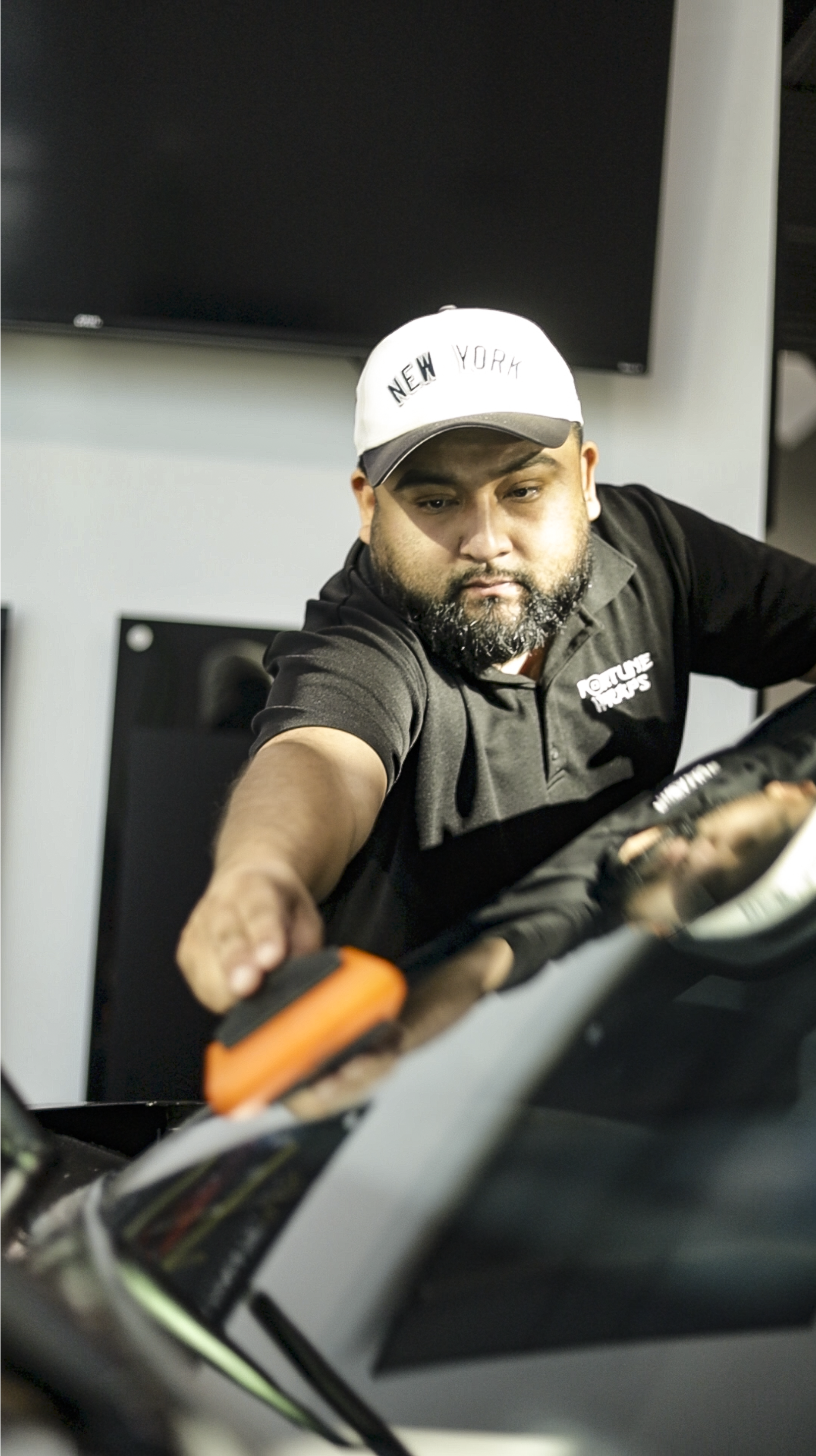 installing windshield protection film on a car with a squeegee