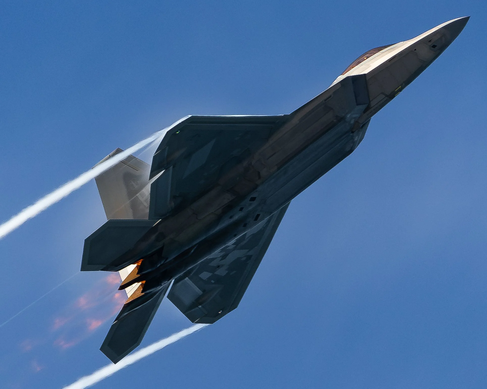 Fighter jet aircraft flying in the sky, leaving white contrails behind.
