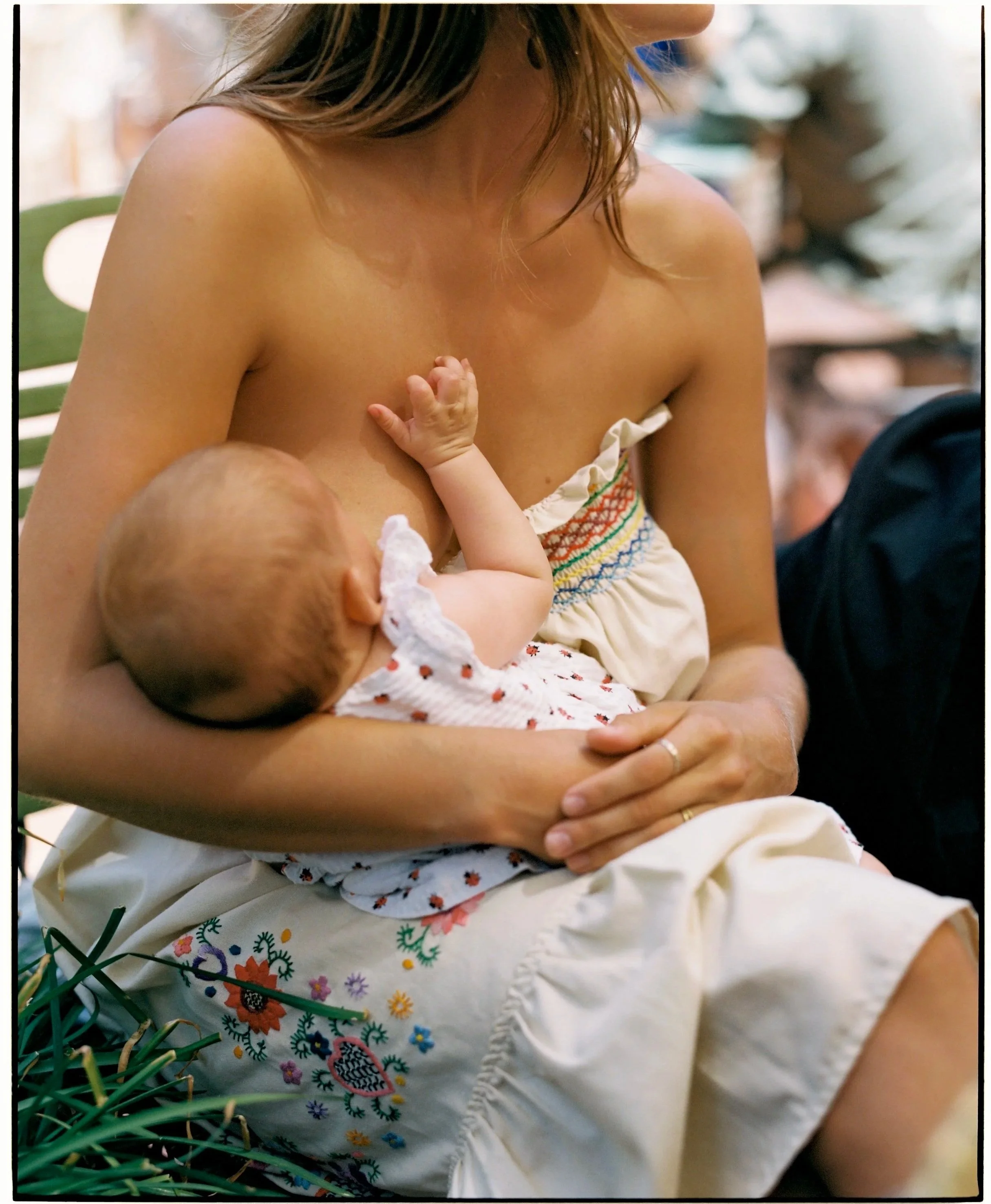A woman breastfeeding a baby in a relaxed setting.