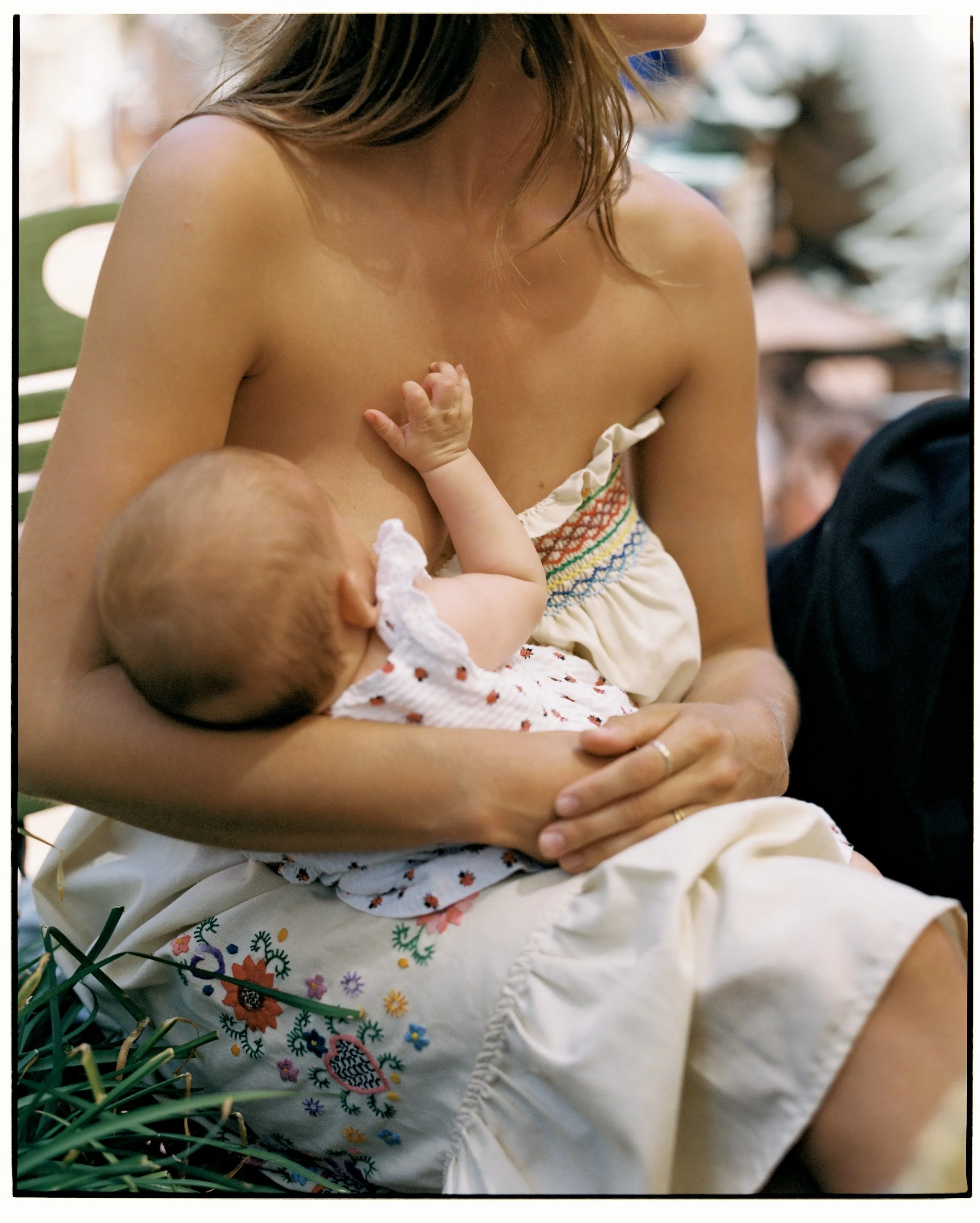 A woman breastfeeding a baby in a relaxed setting.