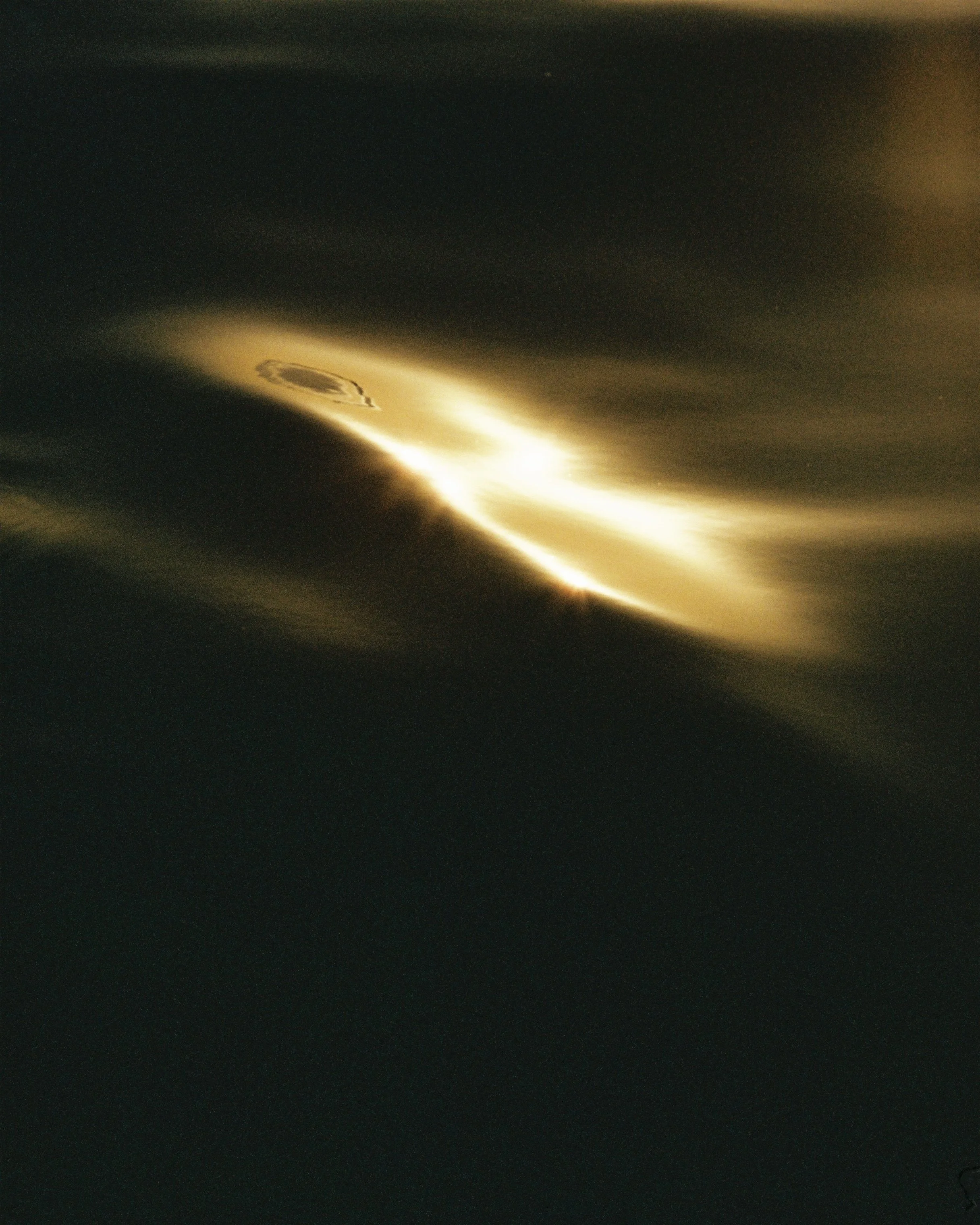 Close-up of a metallic object reflecting sunlight, creating bright, shiny streaks and an interesting pattern.