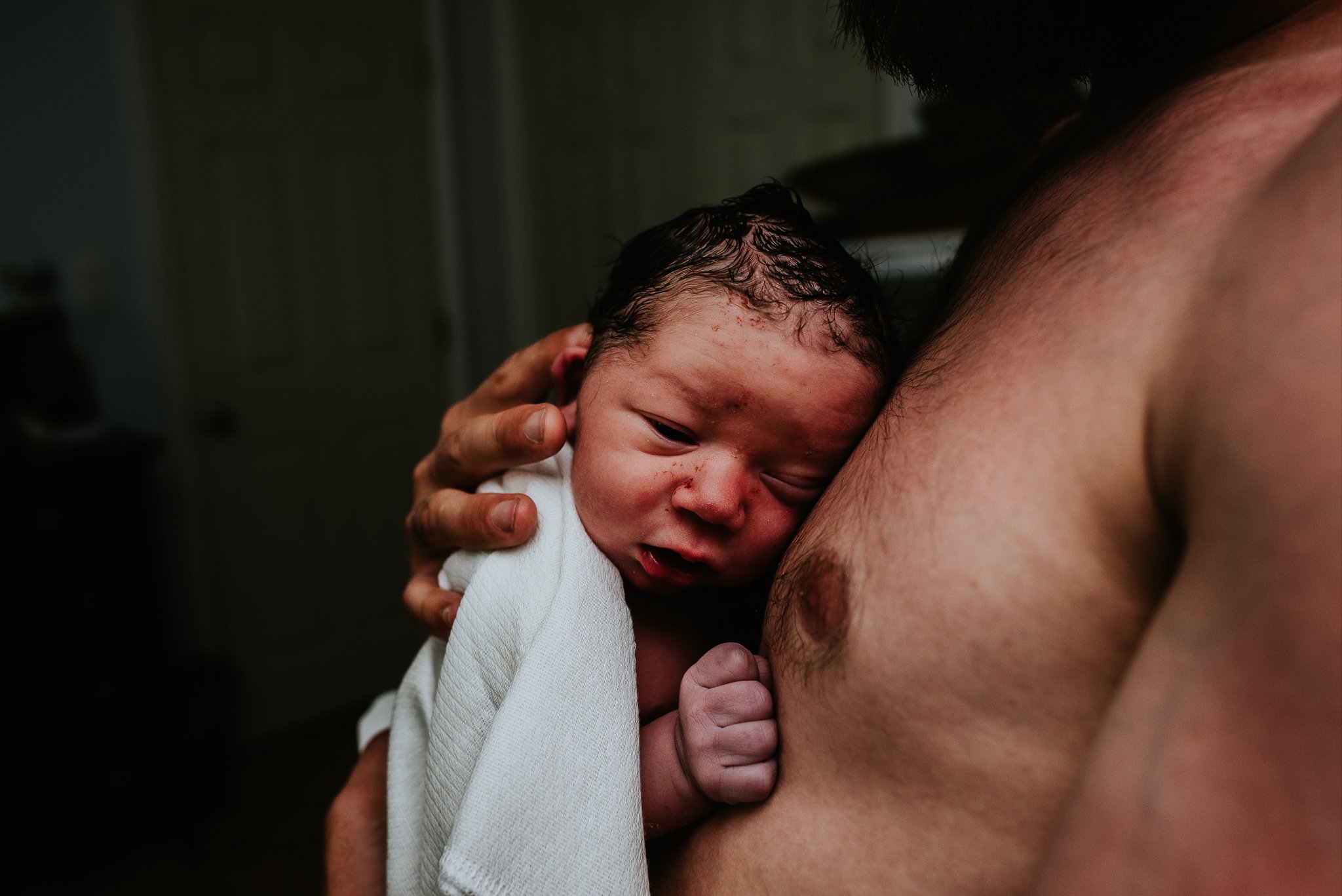 Newborn-held-skin-to-skin-in-central-PA-homebirth-photographed-Badger-and-Quill-Photography