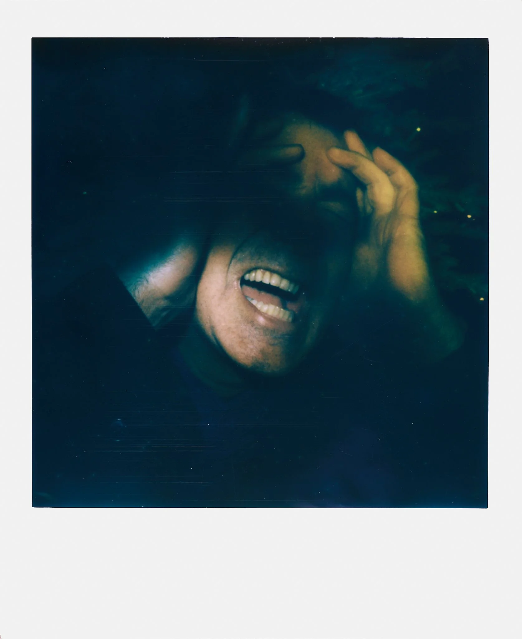 A person underwater with a distressed facial expression, holding their head with one hand.