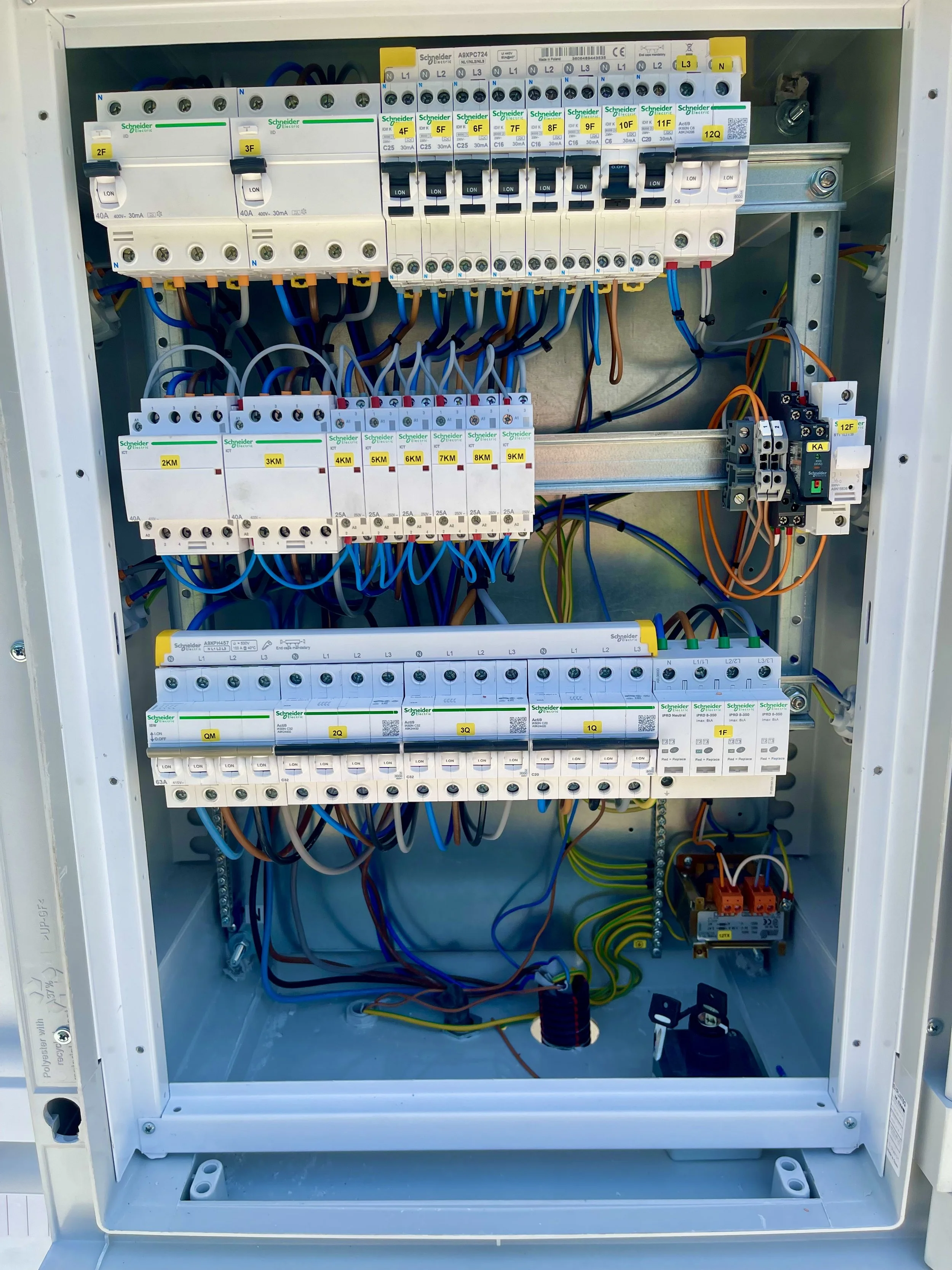 Electrical control panel with circuit breakers and wiring inside a metal enclosure.