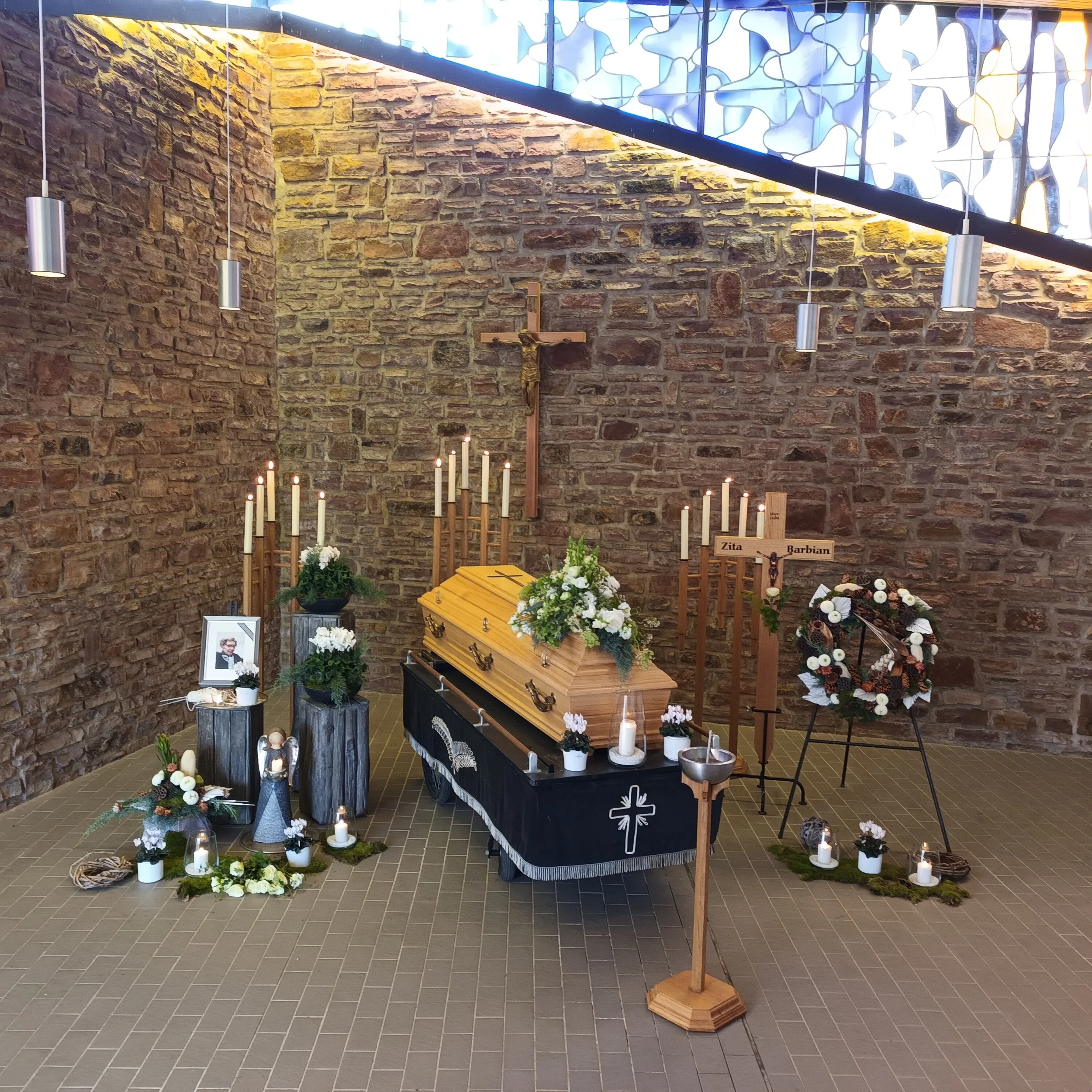 Aufgebahrter Sarg mit Blumen Kränzen und Gestecken in der Aussegnungshalle