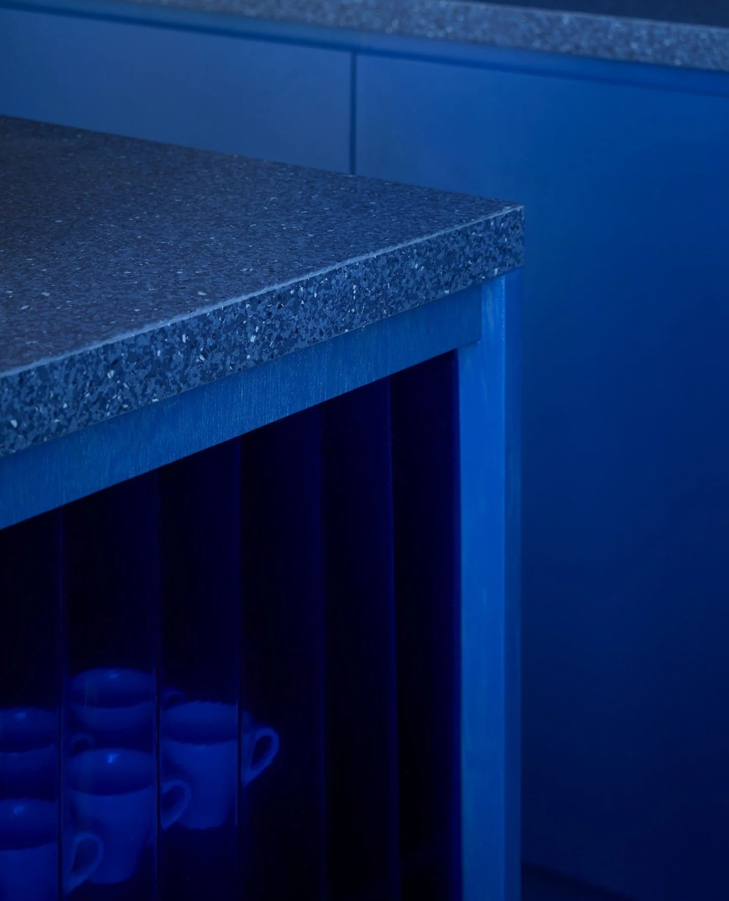 Beneath the training benches, blue-tinted PVC strip curtains conceal the working infrastructure while avoiding the typical &ldquo;staff-only&rdquo; barrier, allowing visitors to comfortably move behind the bar during demonstrations, tastings and even