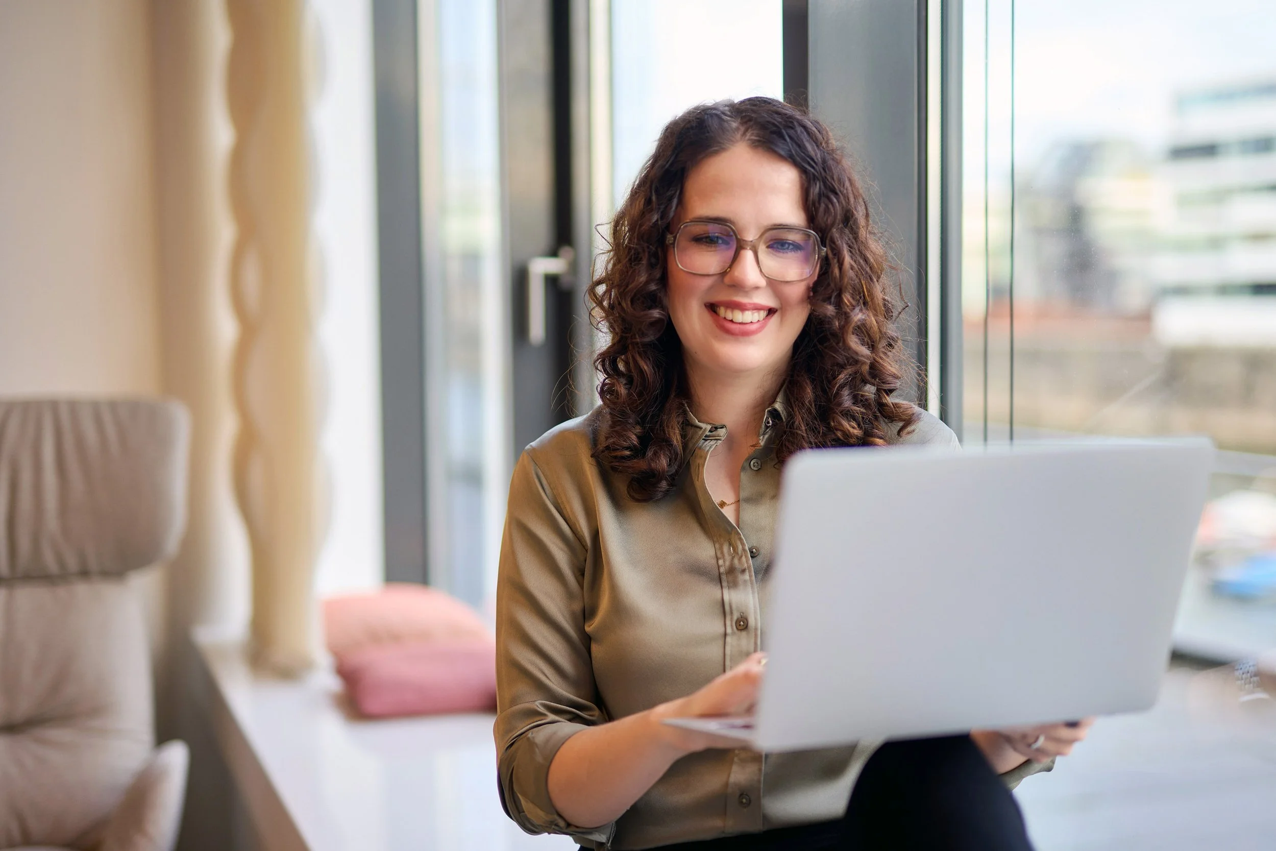 junge Selbständige Consulting arbeitet auf der Fensterbank eines hellen modernen Büros 