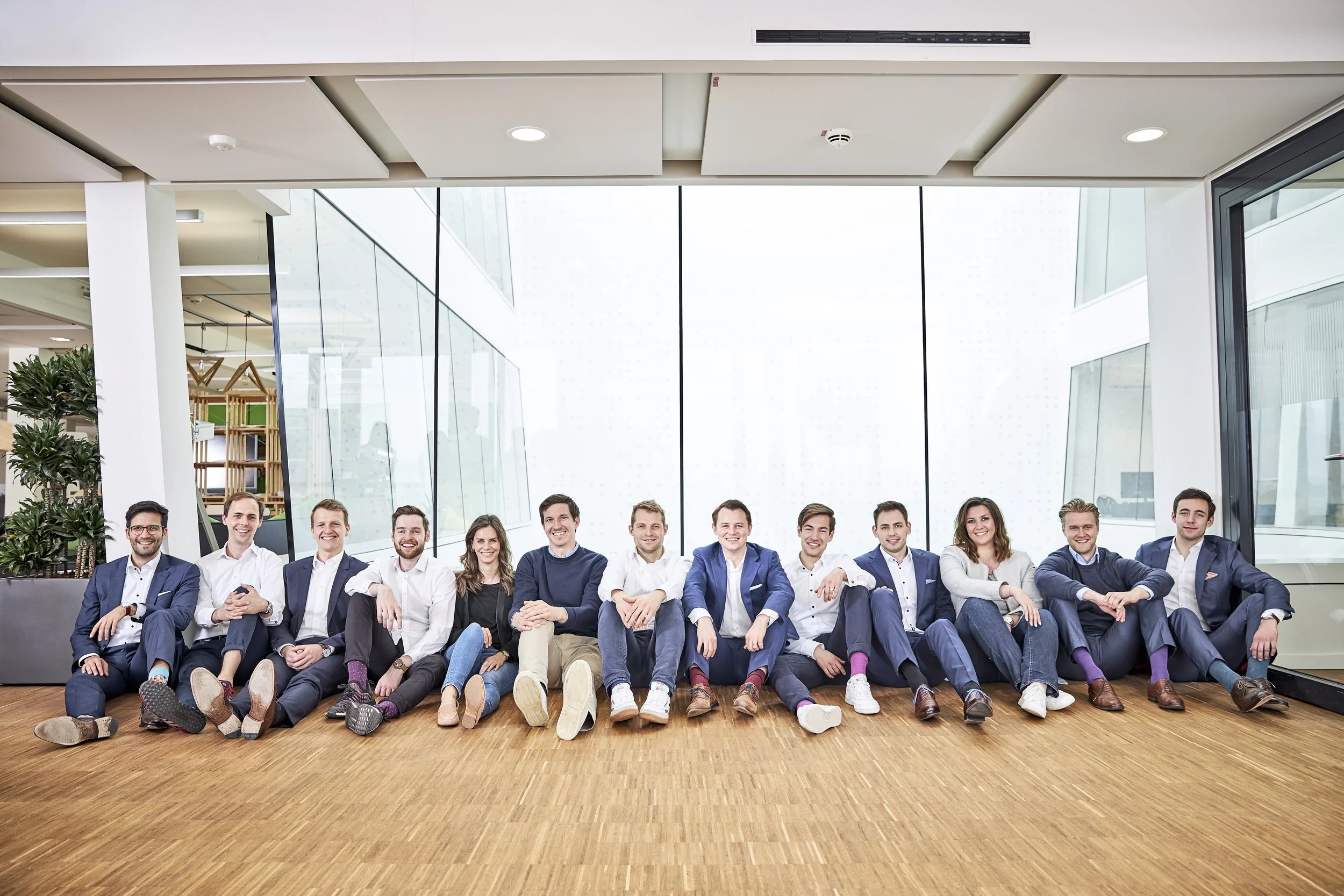 Gruppe von c.a. 20 Menschen sitzend ain einem grossen Büro, corporate Fotografie