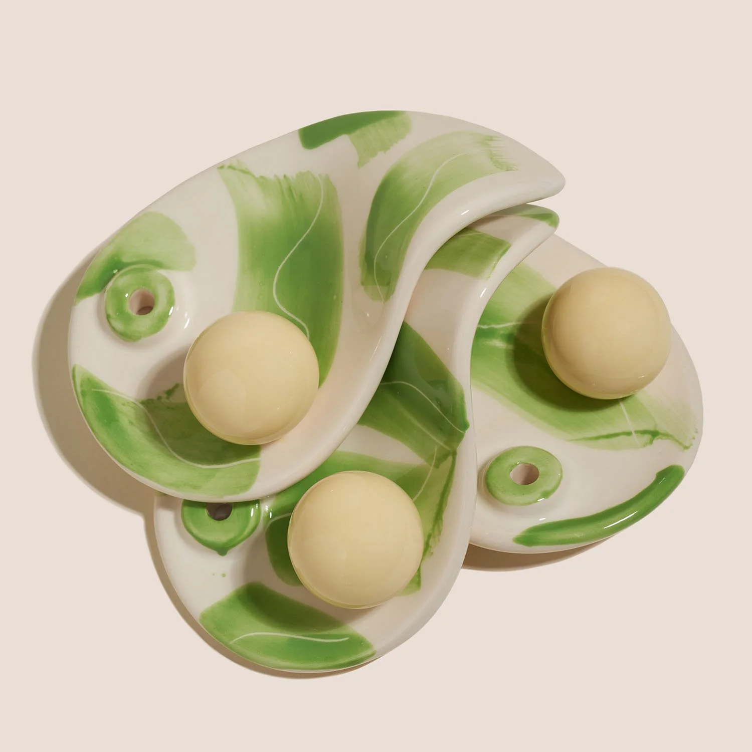 Podstawki na kadzidła z ręcznie malowanym wzorem matcha i kremowymi kulkami, ułożone jedna na drugiej.