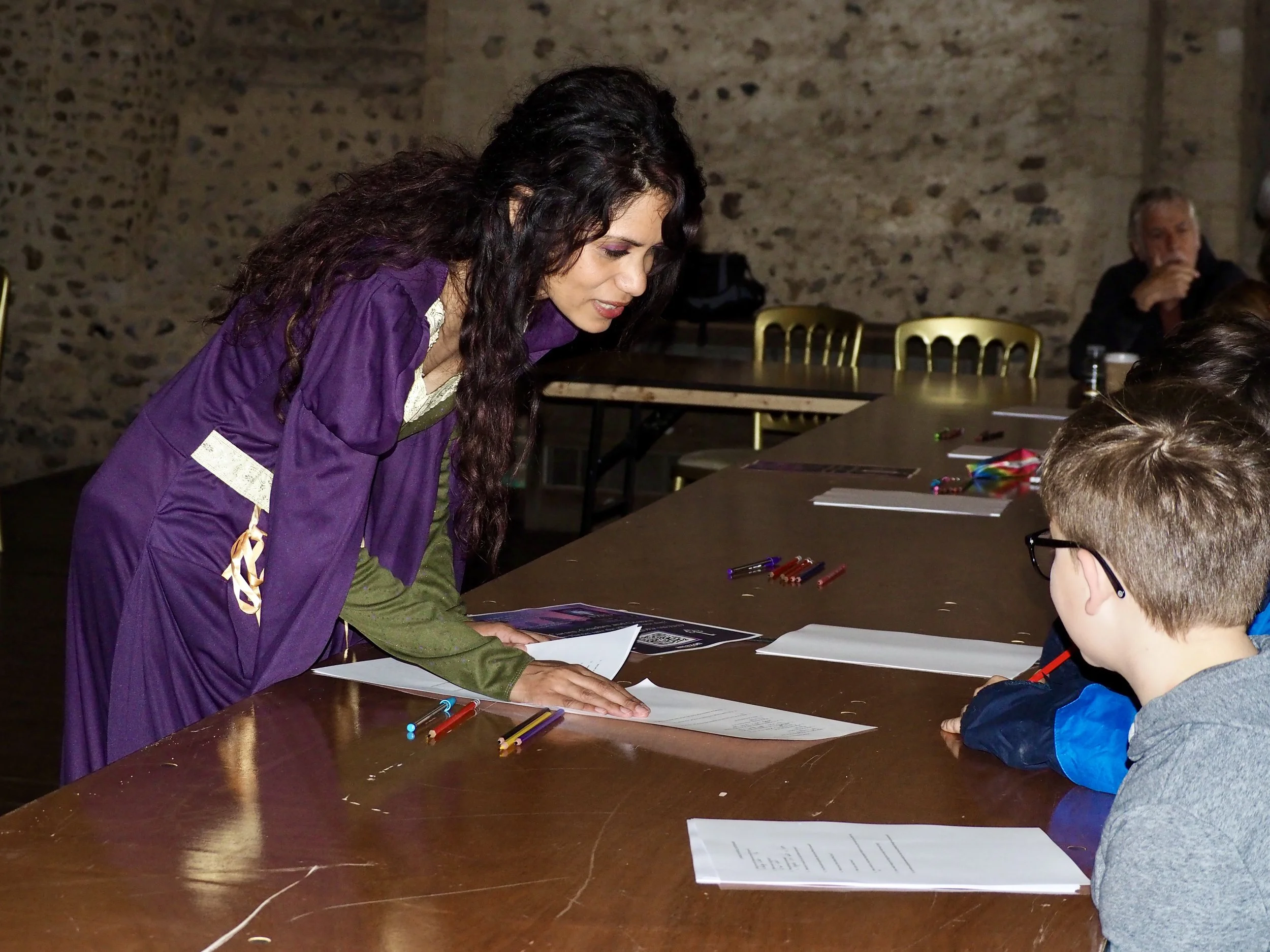 Lisa Wakely Author dressed in a medieval dress talking to children