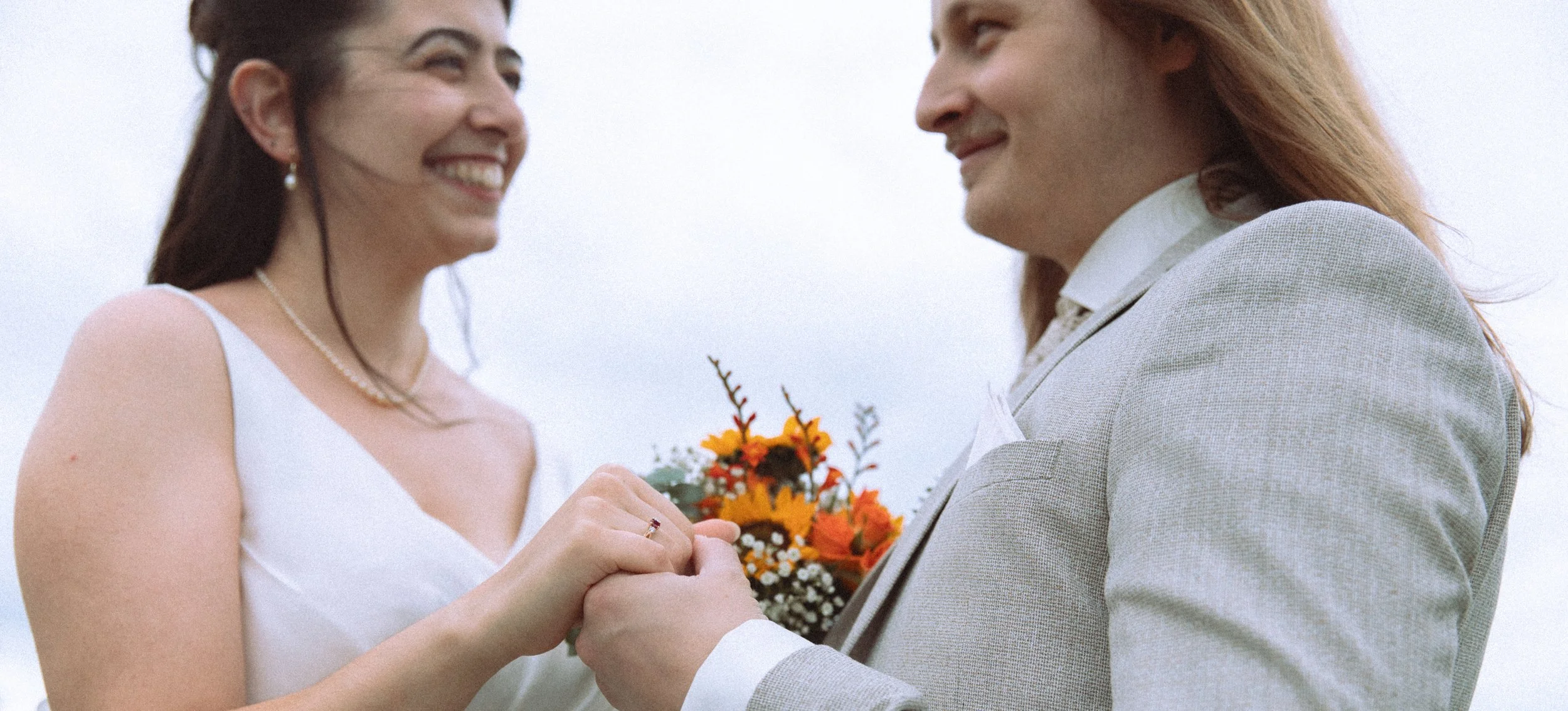 Cinematische trouwfotografie. Filmische stijl koppel handen vast houden.