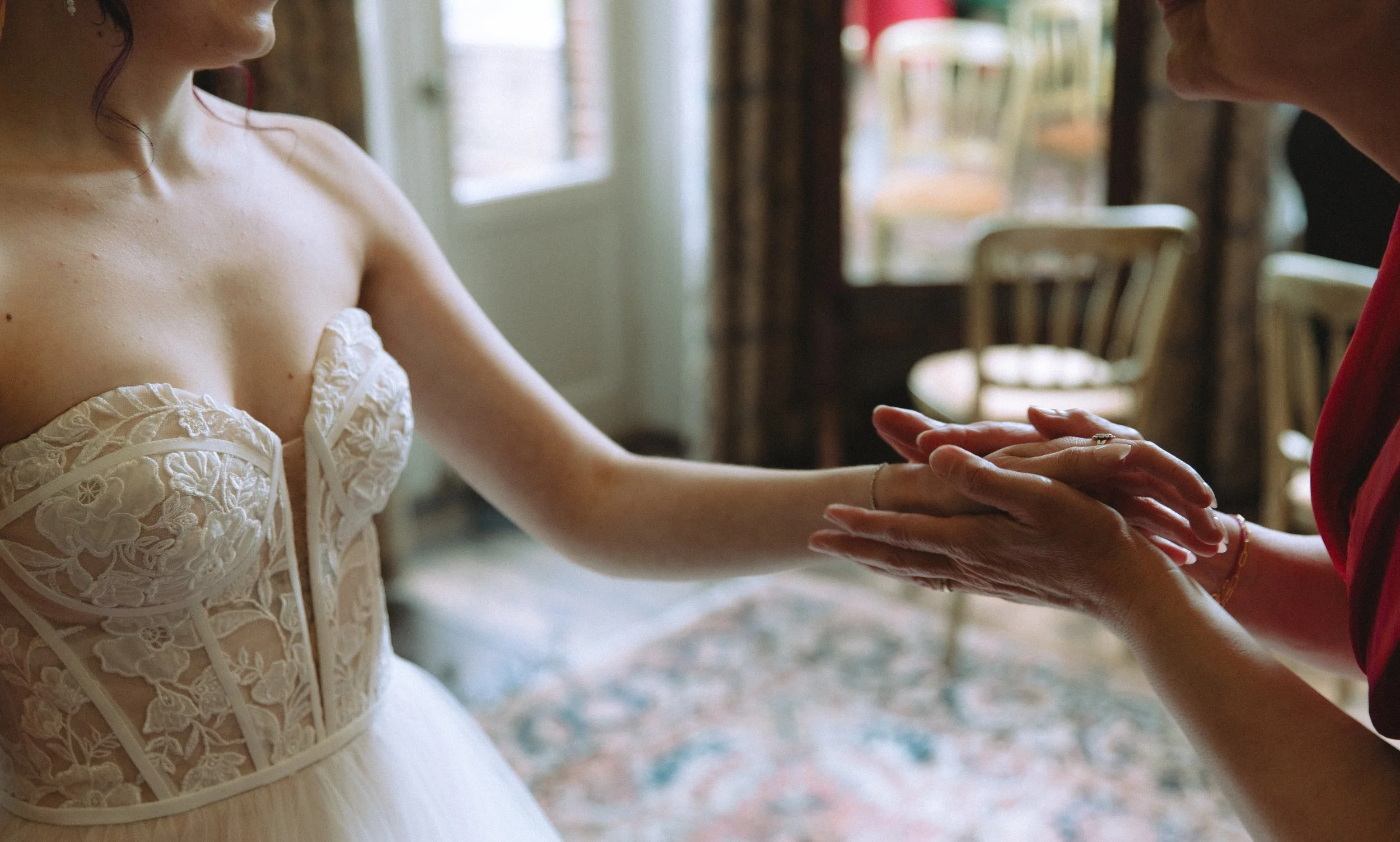 Cinematische trouwfotografie. Filmische stijl detail handen moeder en dochter.