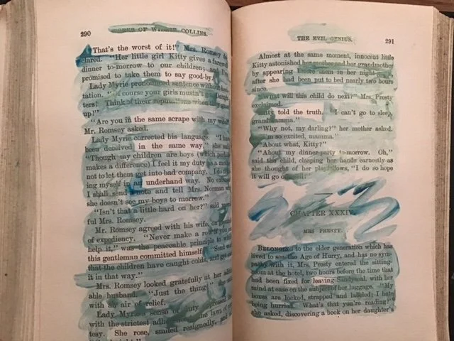 Blue and gold paint on pages of an old book leave a new text.