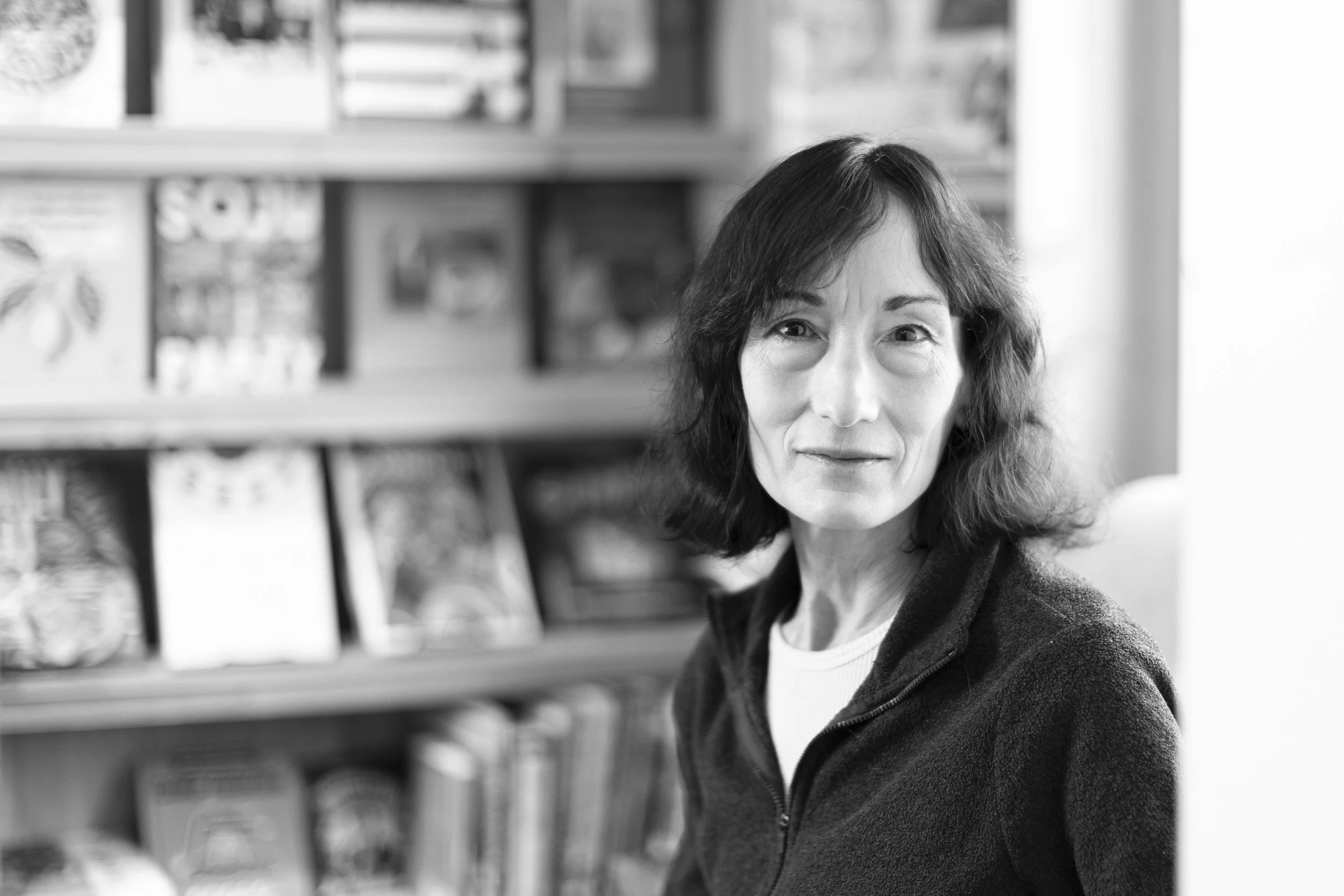 Jessica Roeder in front of a bookshelf in black and white