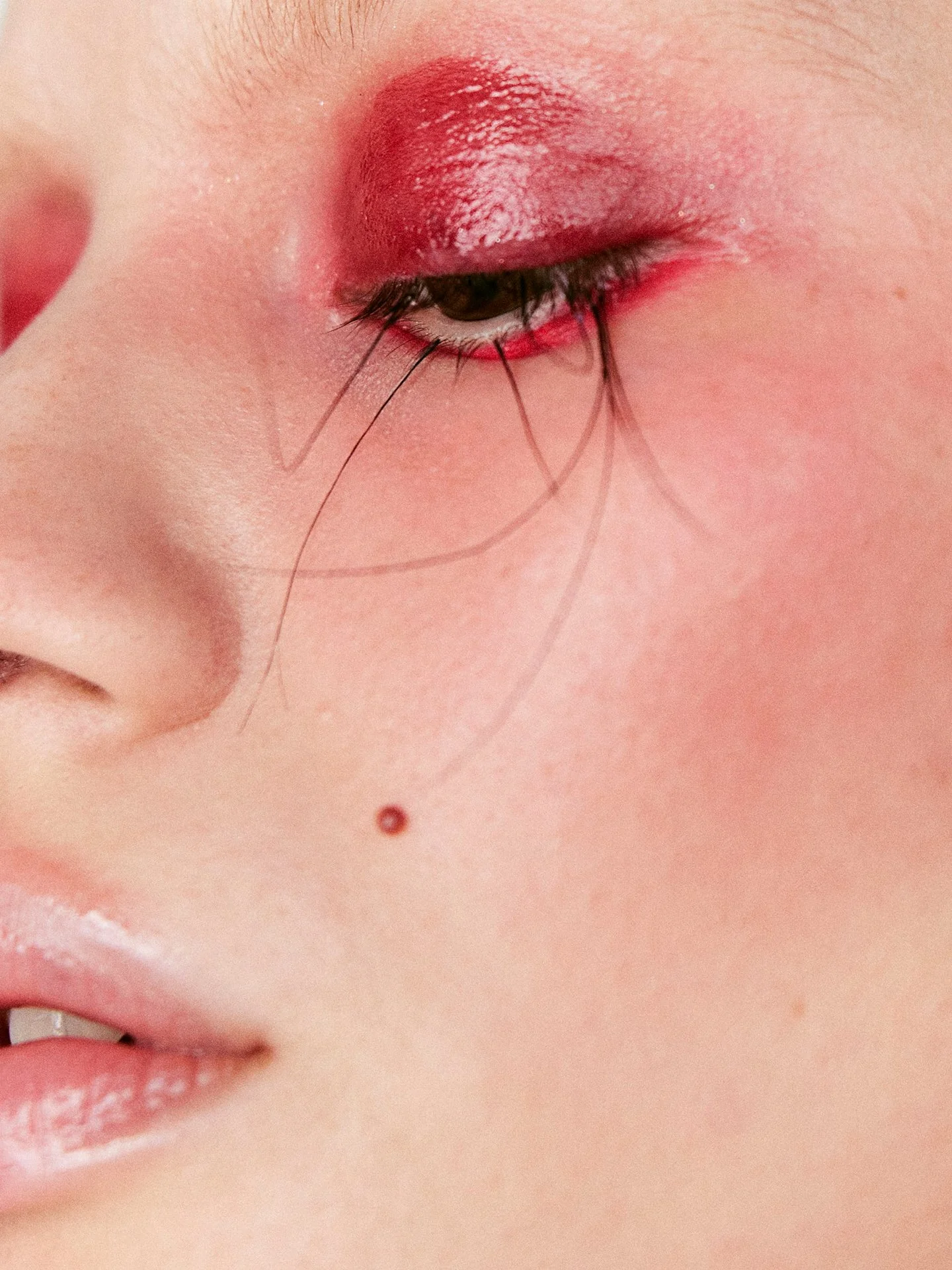 Smudged red eyeshadow beauty close-up by a beauty photographer working in London and Europe