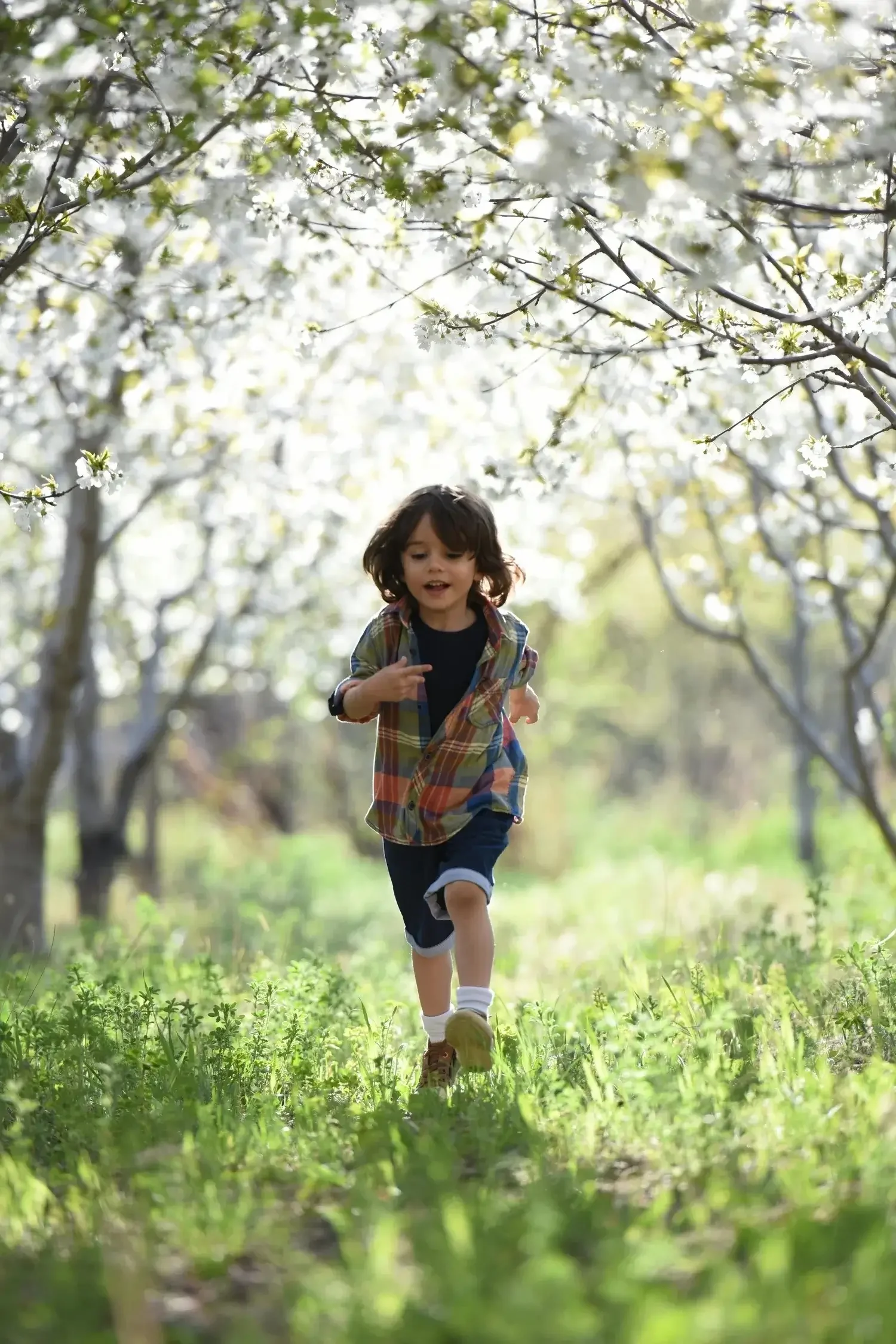 Little kid with smile on his face running through the forest.