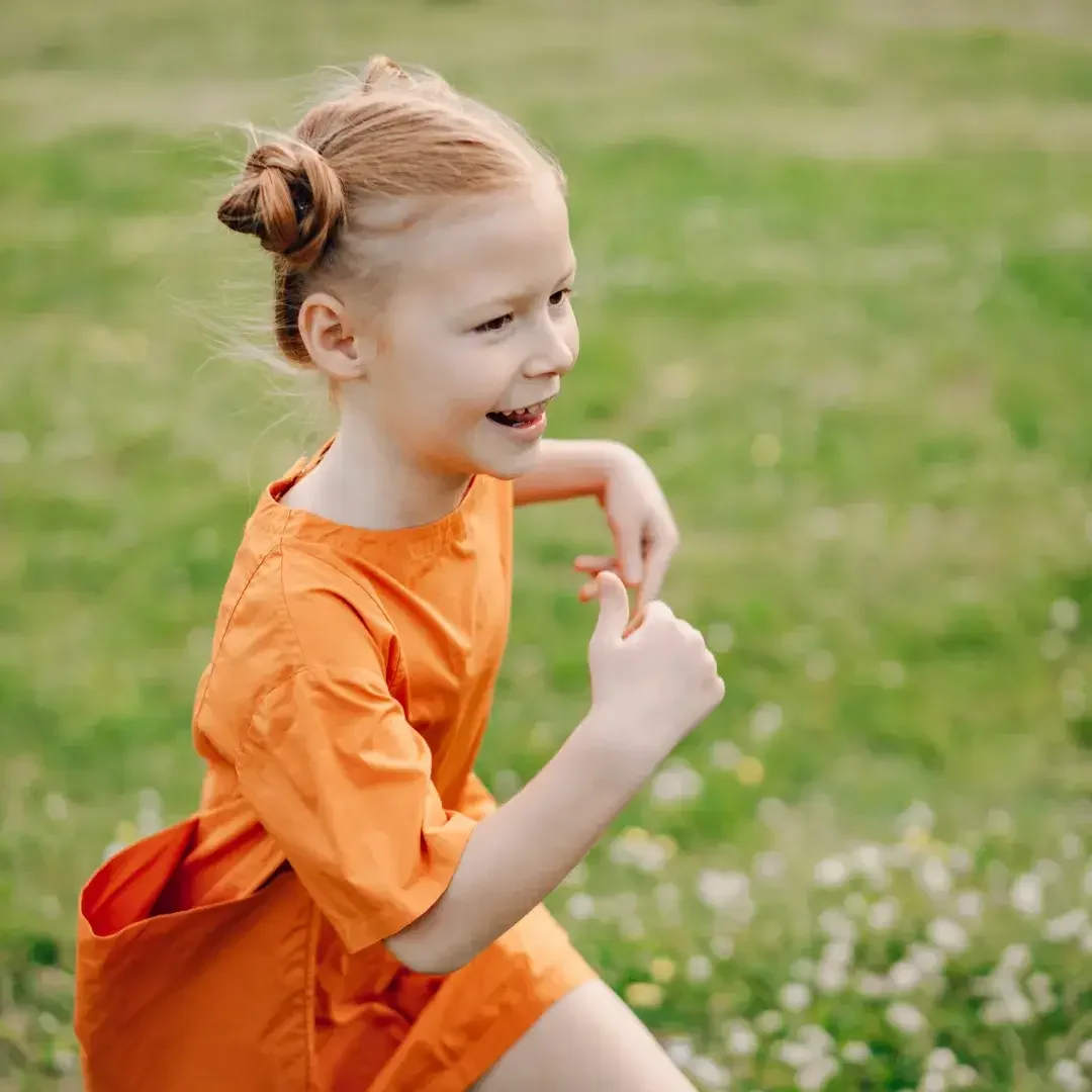 Little girl playing outside on the grass.