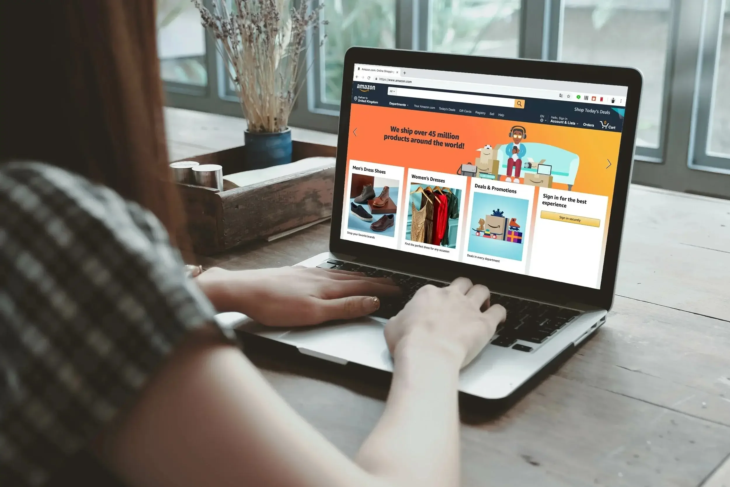 A girl sitting down on her laptop shopping on Amazon.