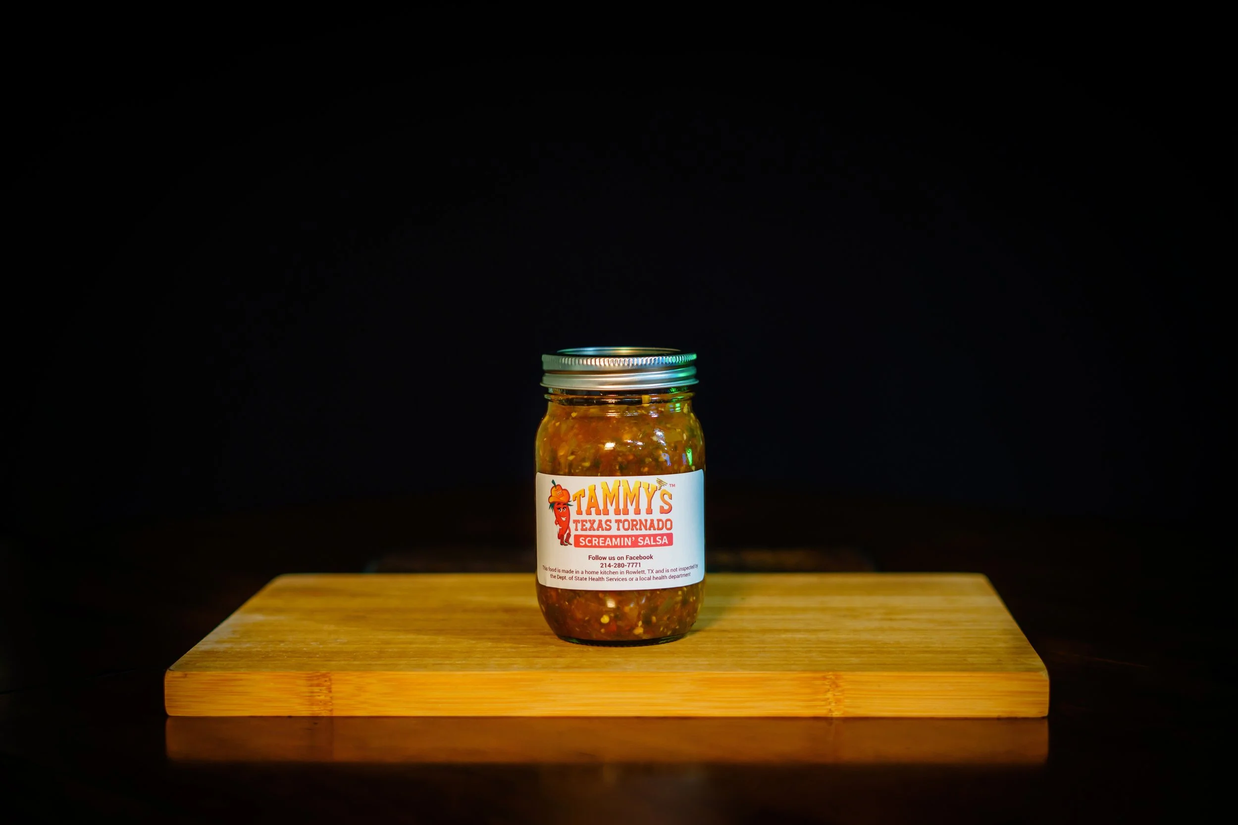 Jar of Tammy's Texas Tornado Screamin' Salsa on a wooden surface.