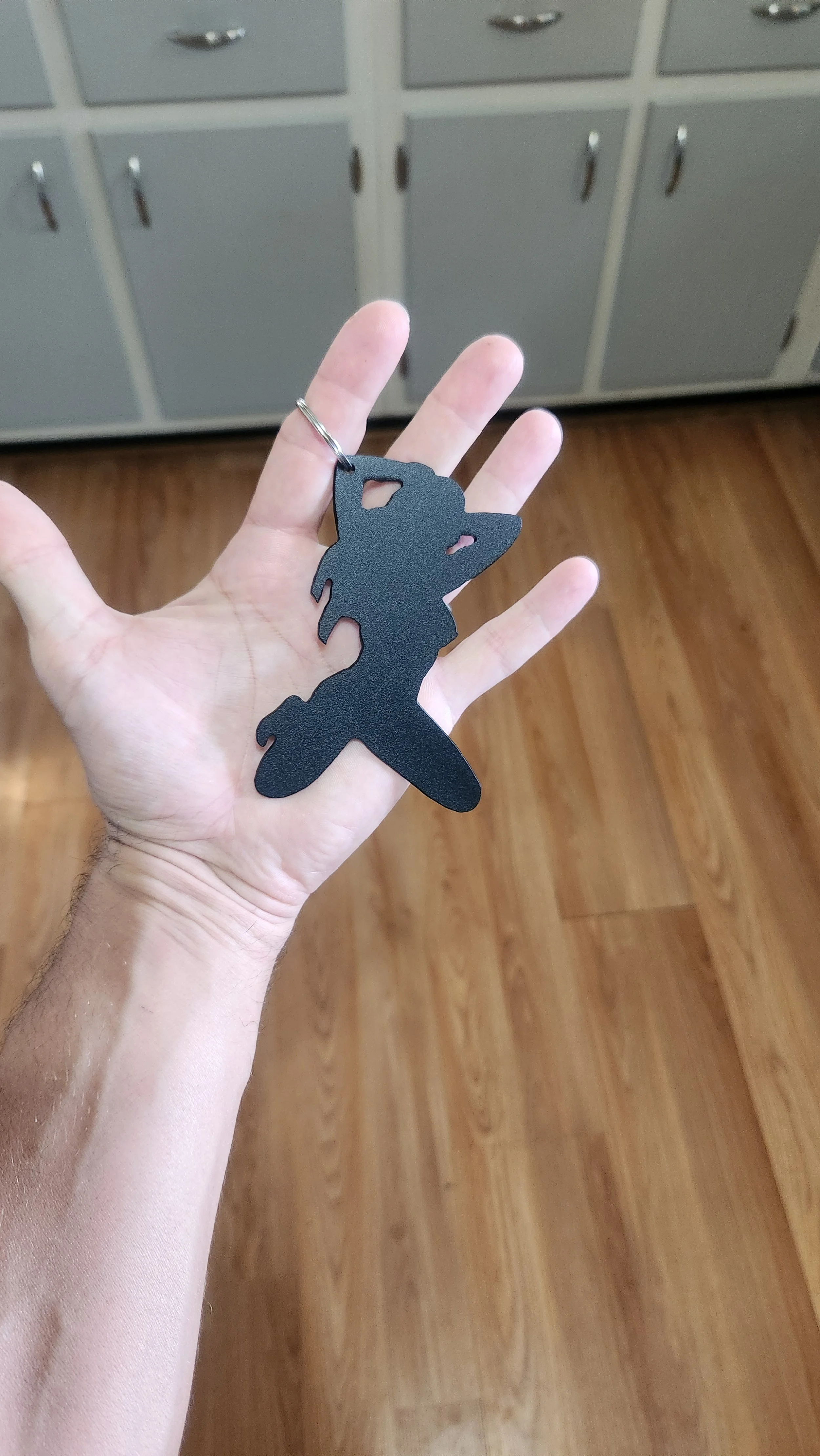 risqué bottle opener shown in hand for size comparison