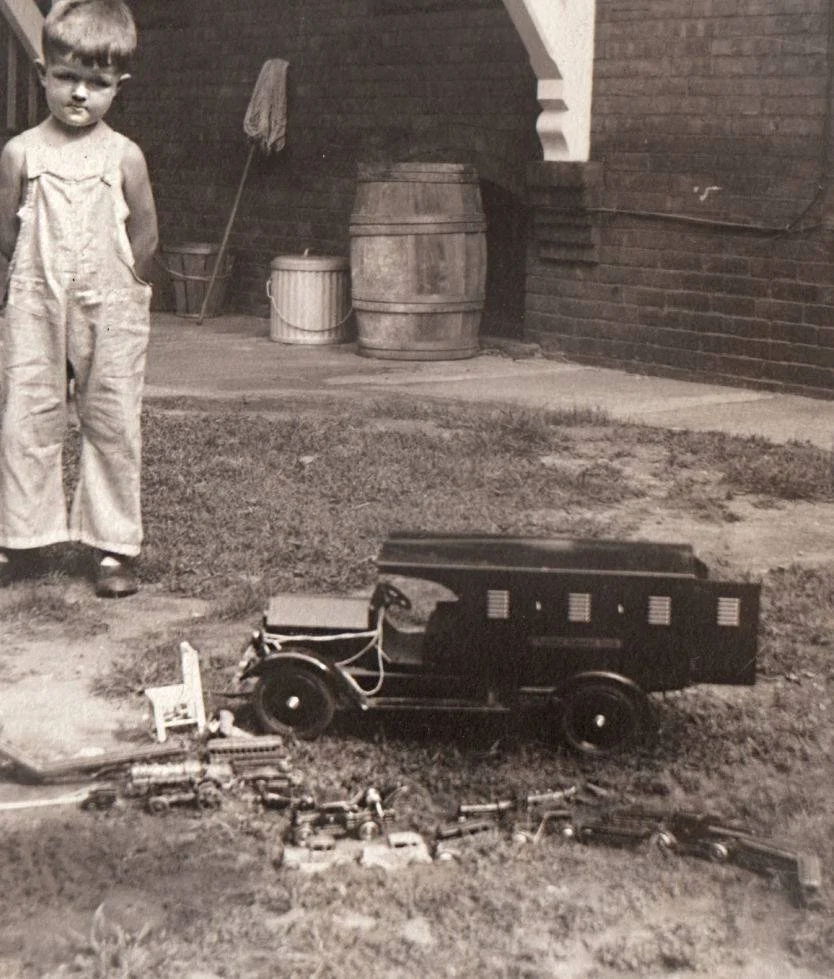 Young Boy with a shiny Sturditoy Armored Car and various other toys.