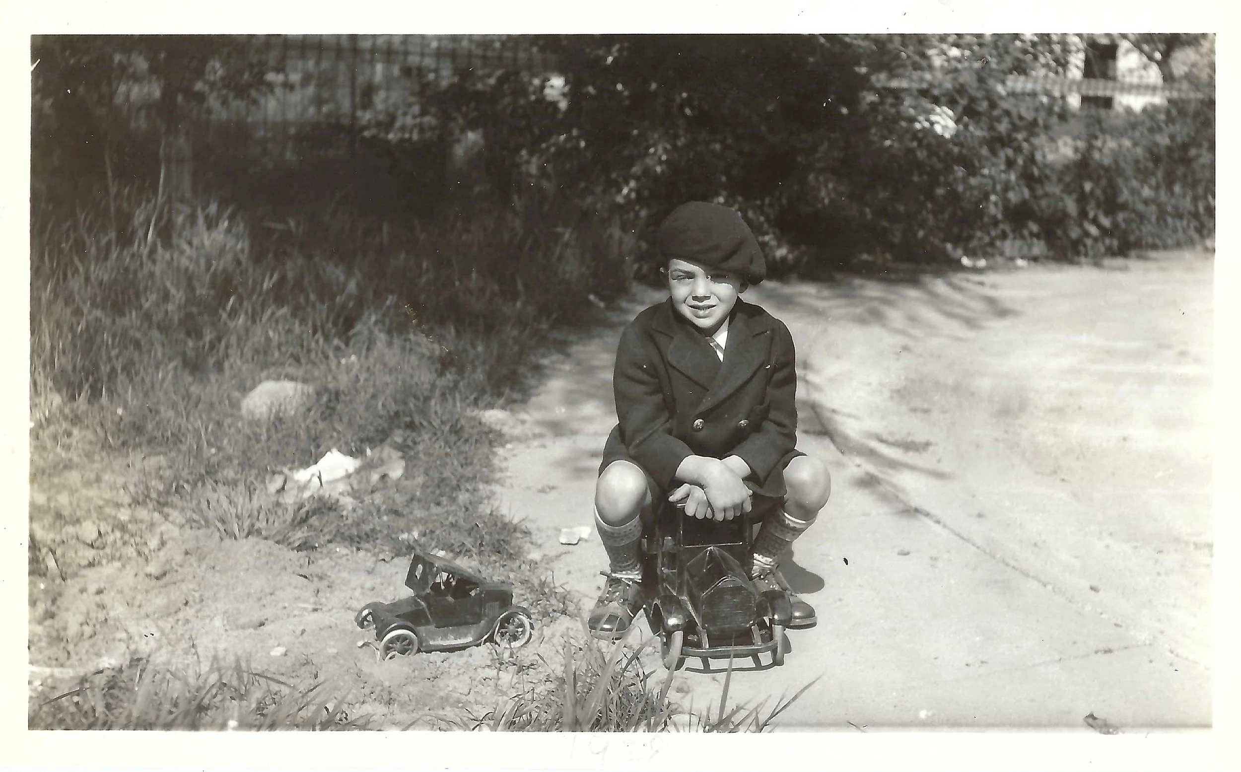 Circa 1928 image of Wilford (Bud) Mason Jr with his Sturditoy Dump Truck and Buddy L Flivver, which has evidently been in a rollover.