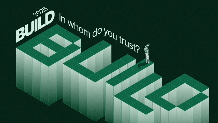 An isometric graphic with large 3D blocks spelling 'BUILD' and a person standing on the last block. The text asks, 'In whom do you trust?' and includes the year 2026. This is advertising the build 2026 conference.
