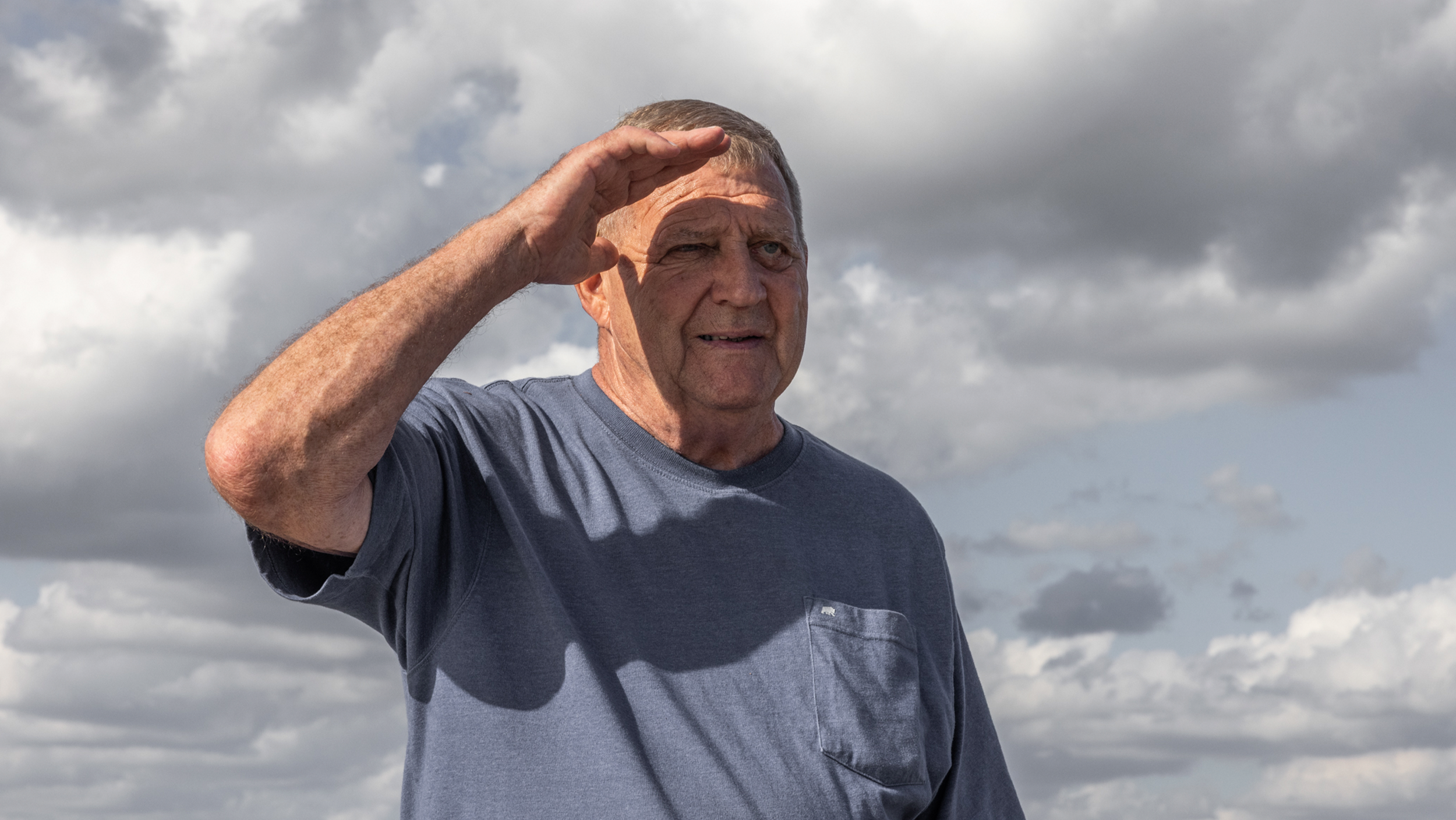 A retired Marine shielding his eyes from the sun