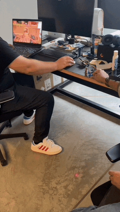 A gamer at his desk while the Laser Cat 3000 laser plays on the floor