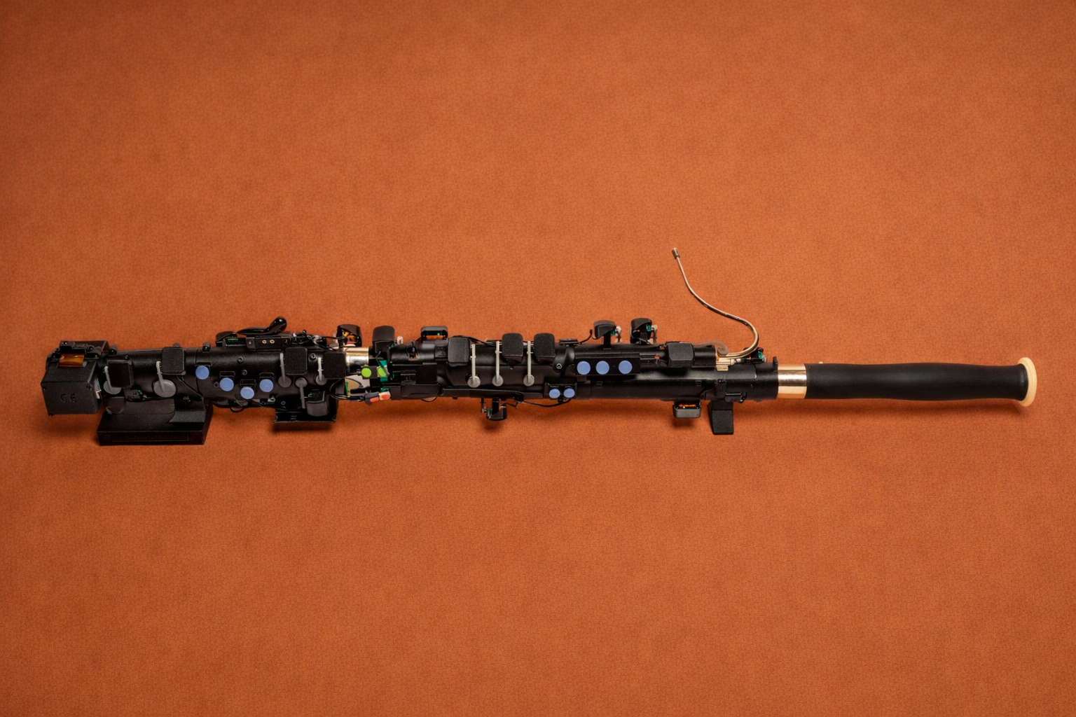 Side profile of the Densoon assisted bassoon on a burnt orange background