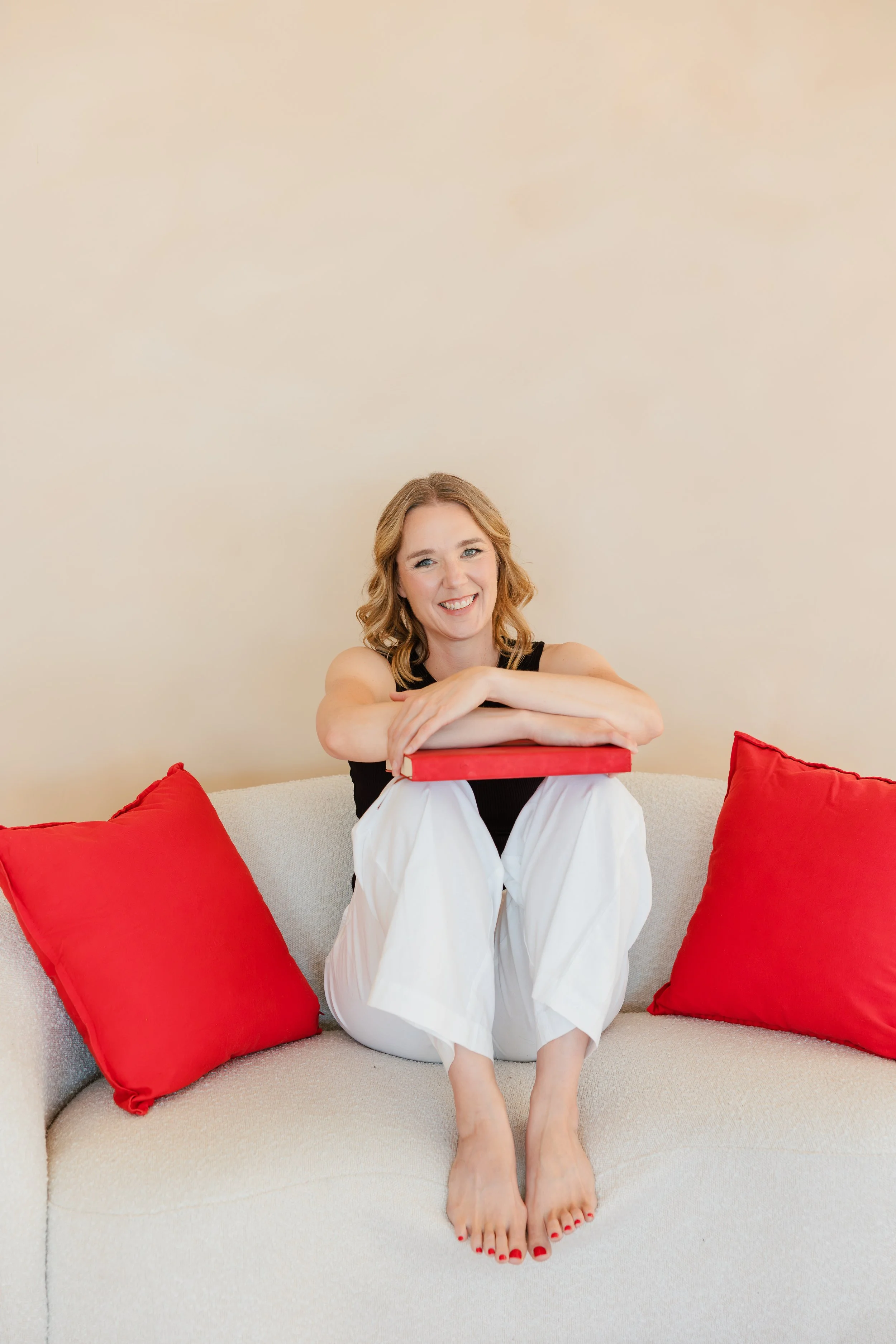 Baby sitting on carpet with adult holding foot
