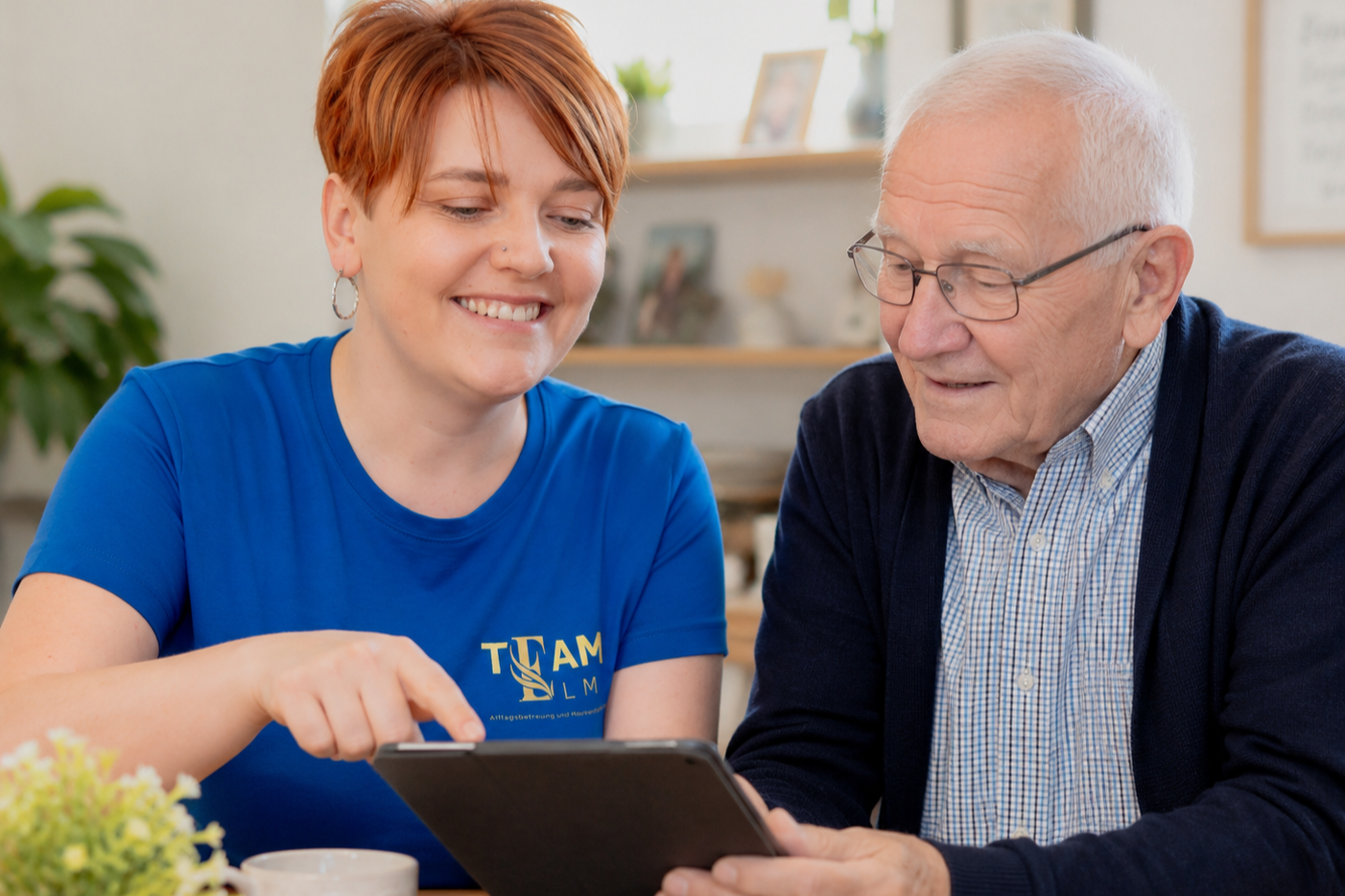 Stefanie erklärt einem Senior ein Tablet