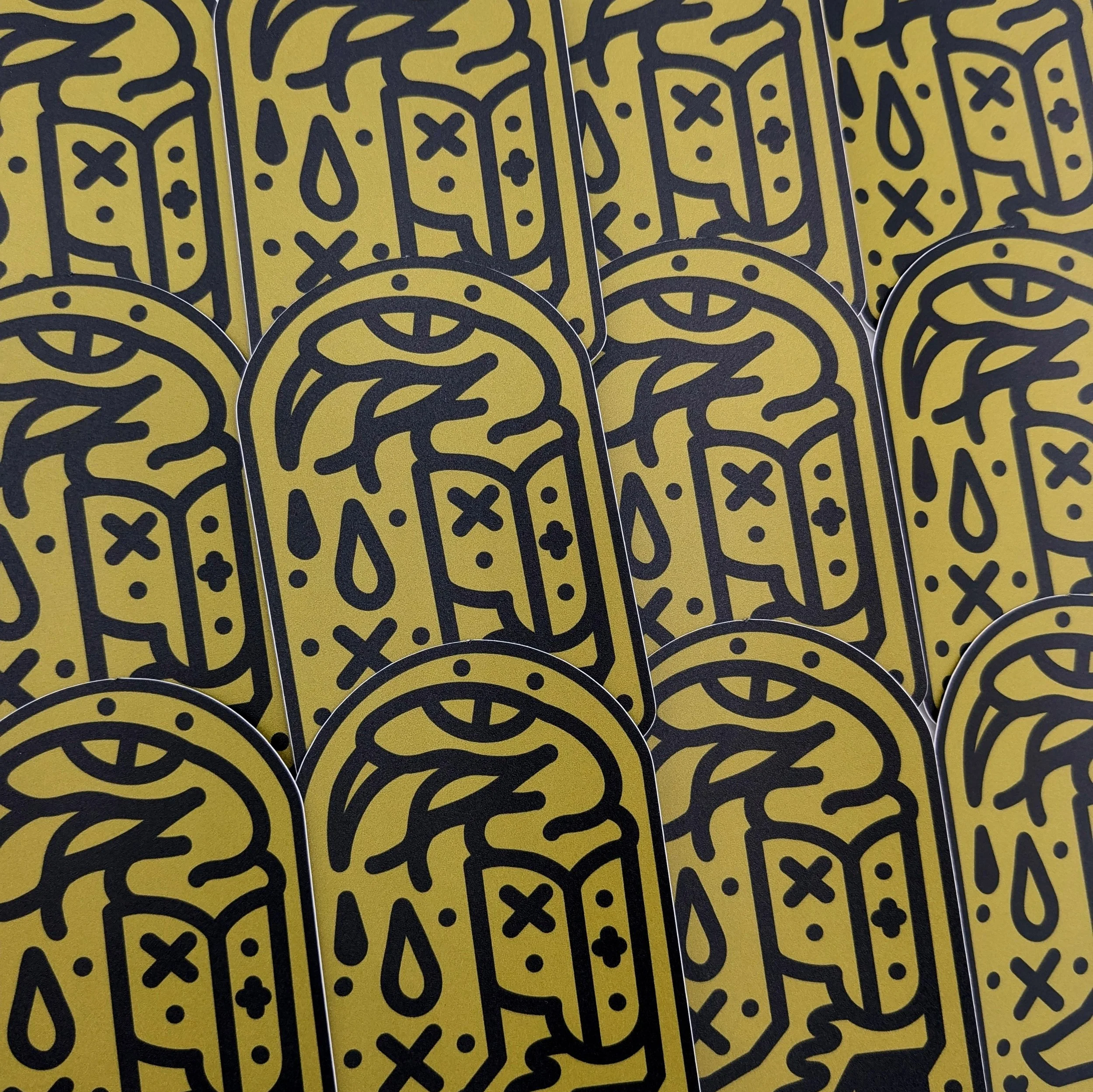 Many Boot Snake stickers arranged in a repeating pattern. They are gold and black American Traditional styled snakes in boots, with venom dripping from it's mouth.